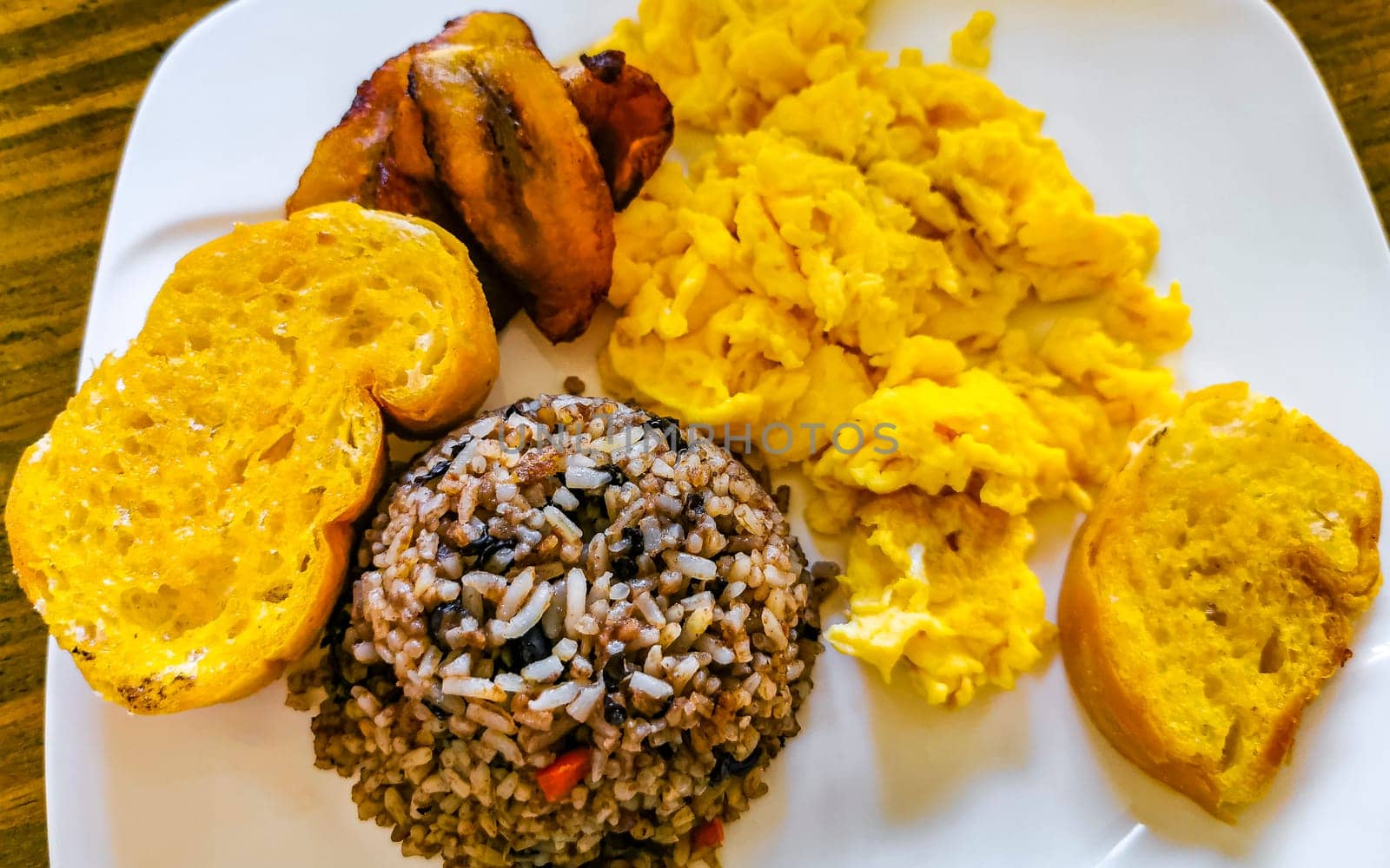 Costa Rican food dish Rice Banana Scrambled eggs Beans bread. by Arkadij
