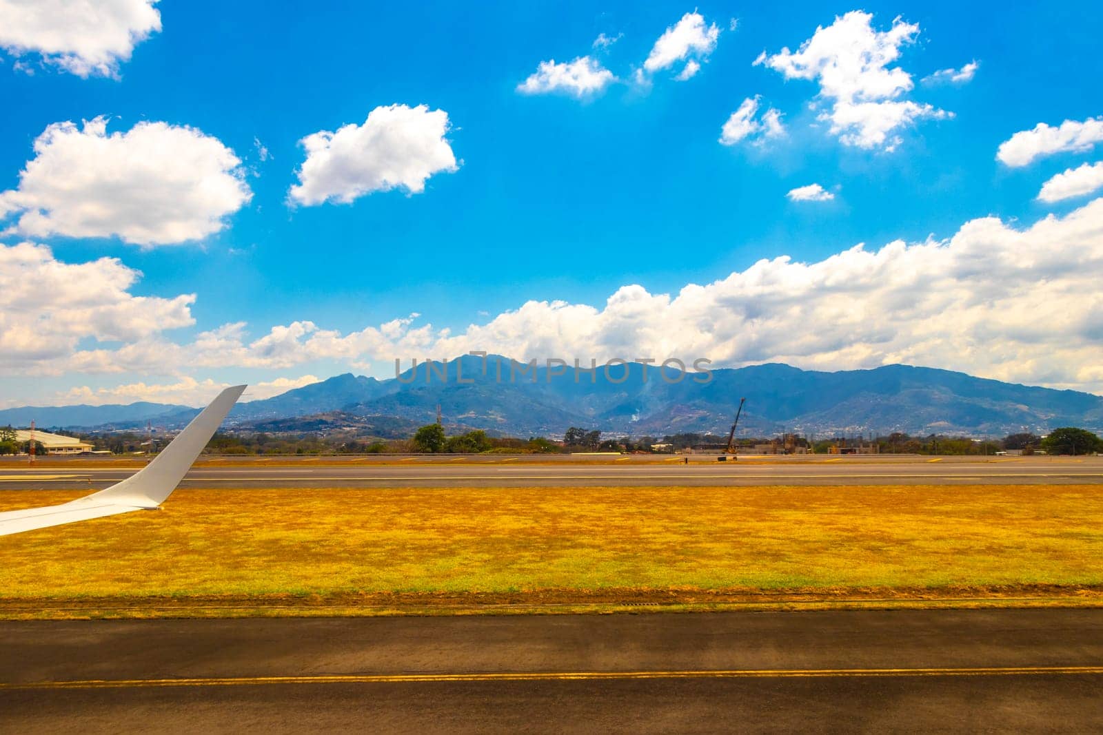 Runway airport city mountains panorama view from airplane Costa Rica. by Arkadij