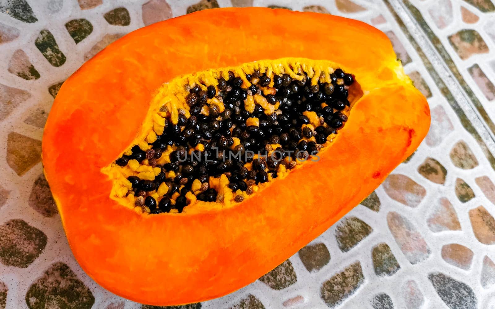 Half papaya in hand with background in Playa del Carmen Quintana Roo Mexico.