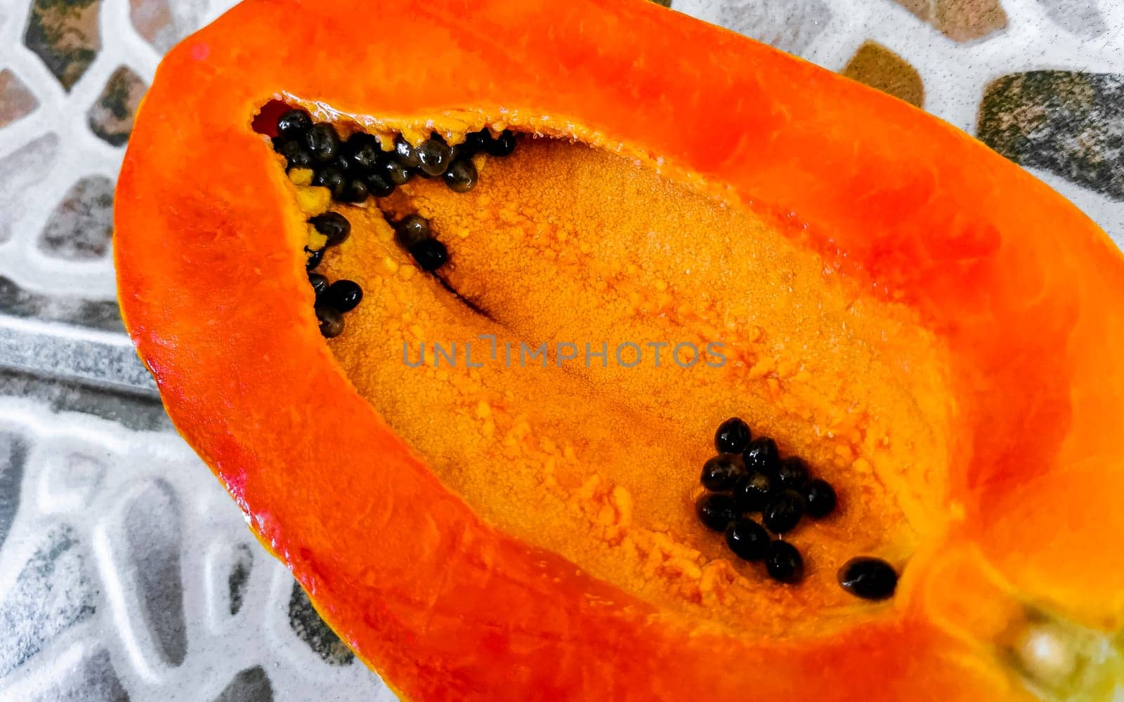 Half papaya in hand with background in Mexico. by Arkadij