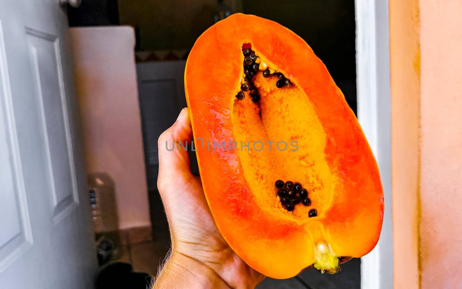 Half papaya in hand with background in Playa del Carmen Quintana Roo Mexico.