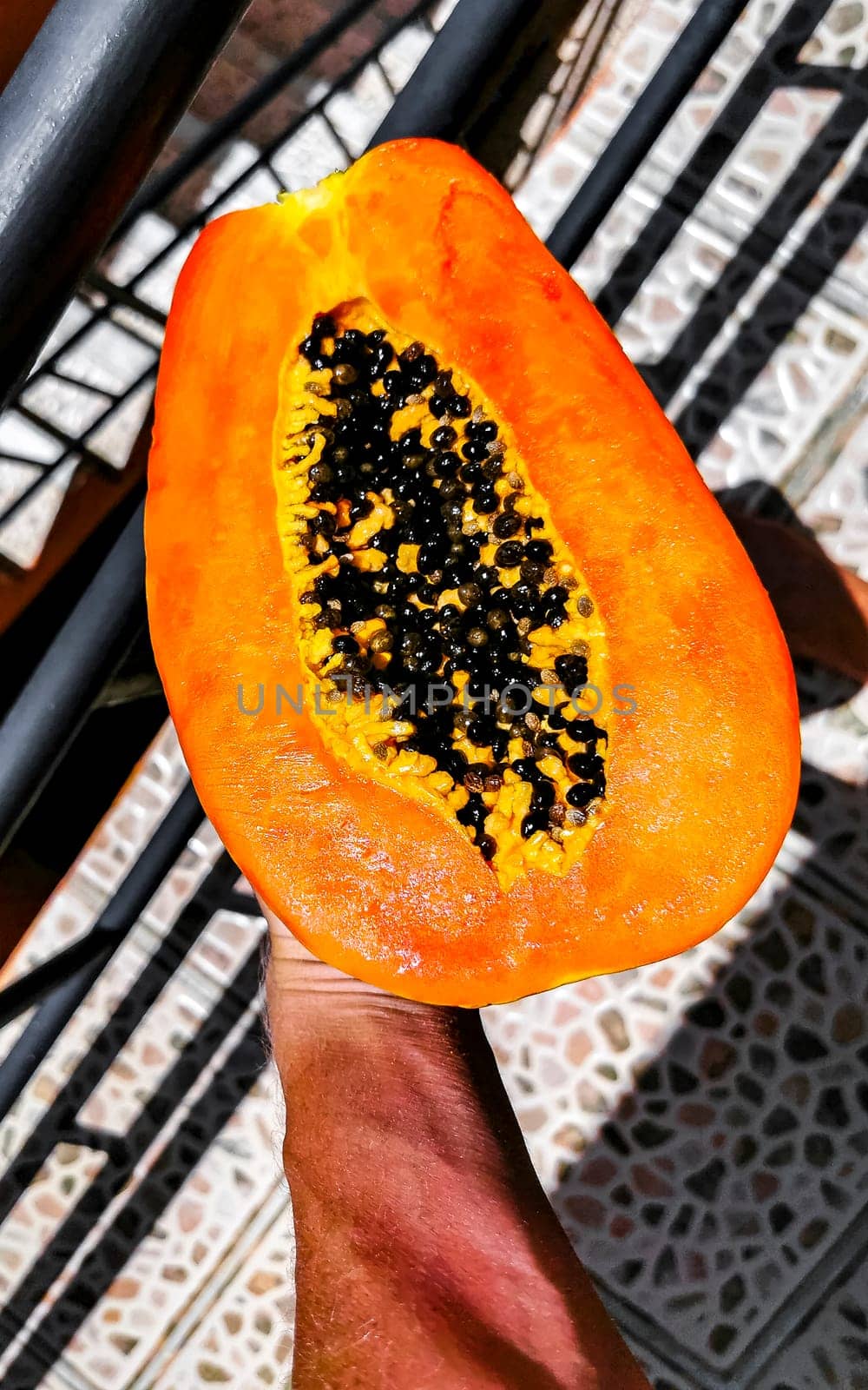 Half papaya in hand with background in Playa del Carmen Quintana Roo Mexico.