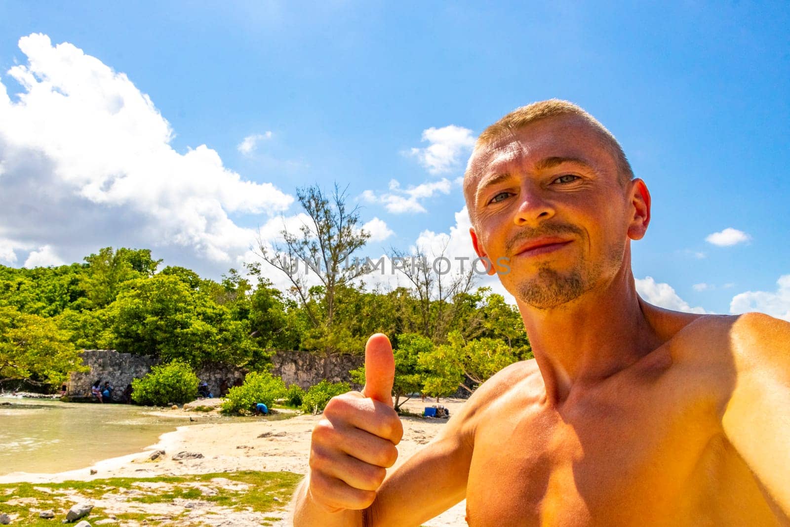 Male tourist Travelling man taking selfie photo on the beach in Playa del Carmen Quintana Roo Mexico.
