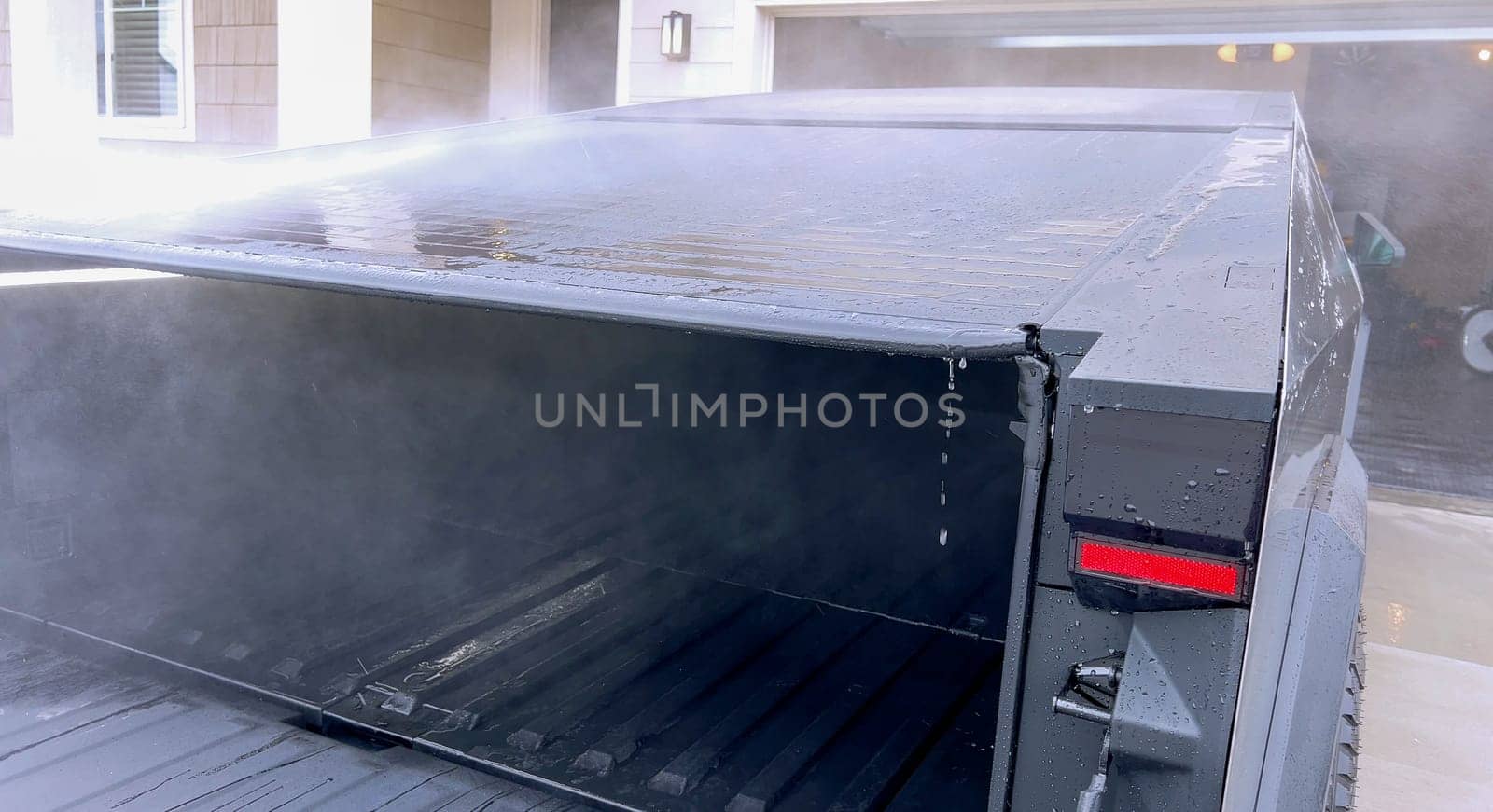 Denver, Colorado, USA-April 28, 2024- This image captures a Tesla Cybertruck undergoing a thorough cleaning, focusing on the high-pressure washing of its cargo bed, demonstrating the maintenance of its durable and robust design. High-Pressure Cleaning of the Tesla Cybertruck Cargo Bed. High quality photo