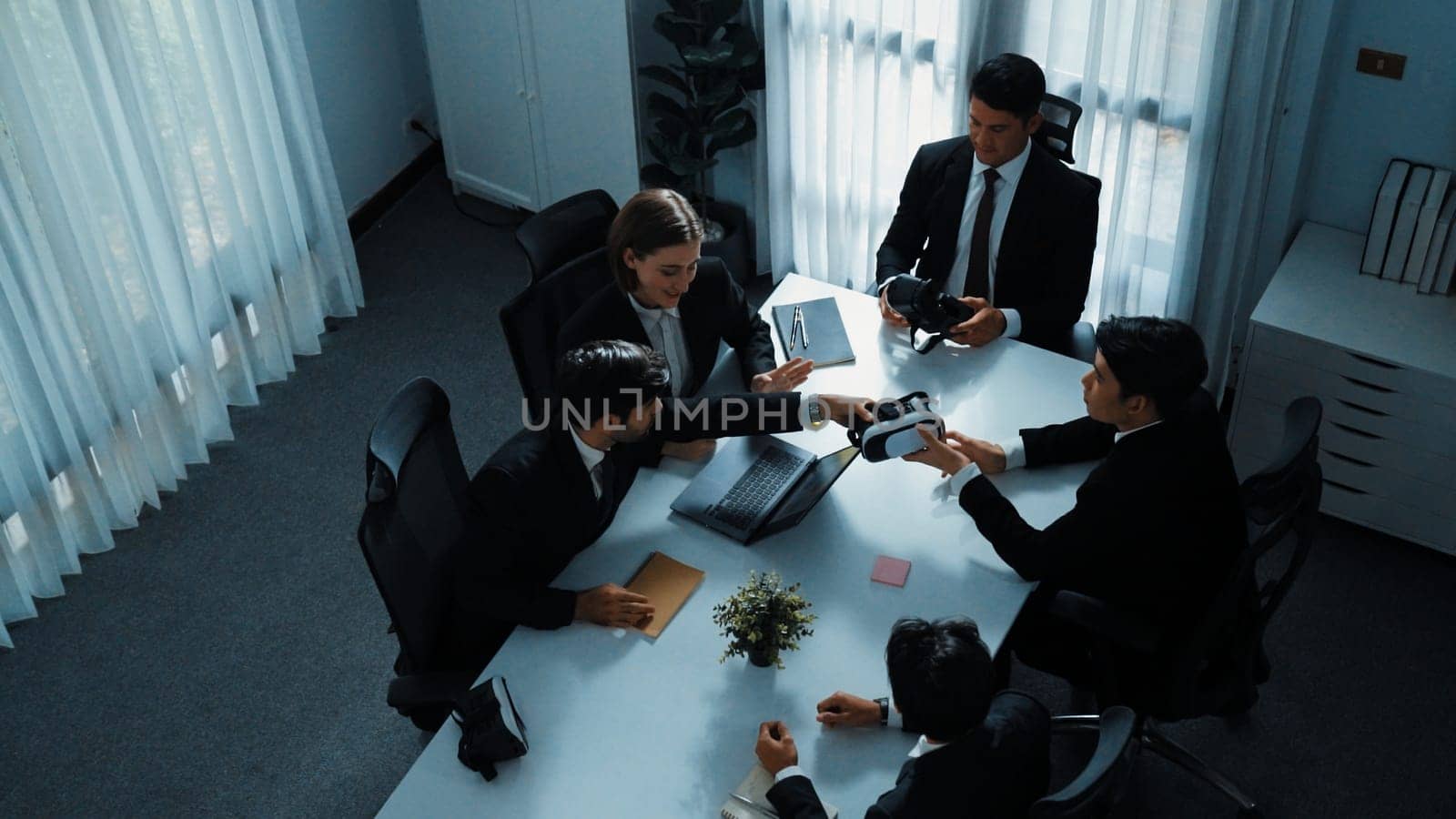 Top view of manager working on laptop and sending data analysis to business people by using VR glass headset while diverse team moving gesture while working together to planning idea. Directorate.