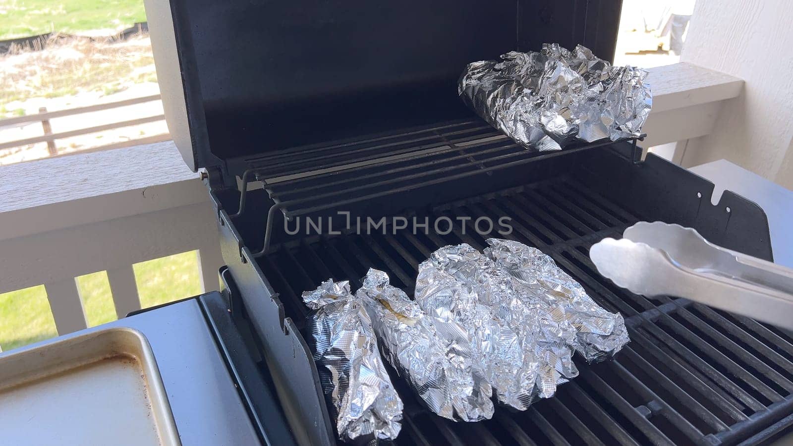 Corn on the Cob Wrapped in Foil Grilling on a Barbecue by arinahabich