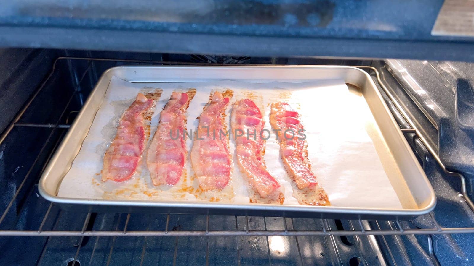 Bacon Strips Cooking to Perfection in the Oven by arinahabich