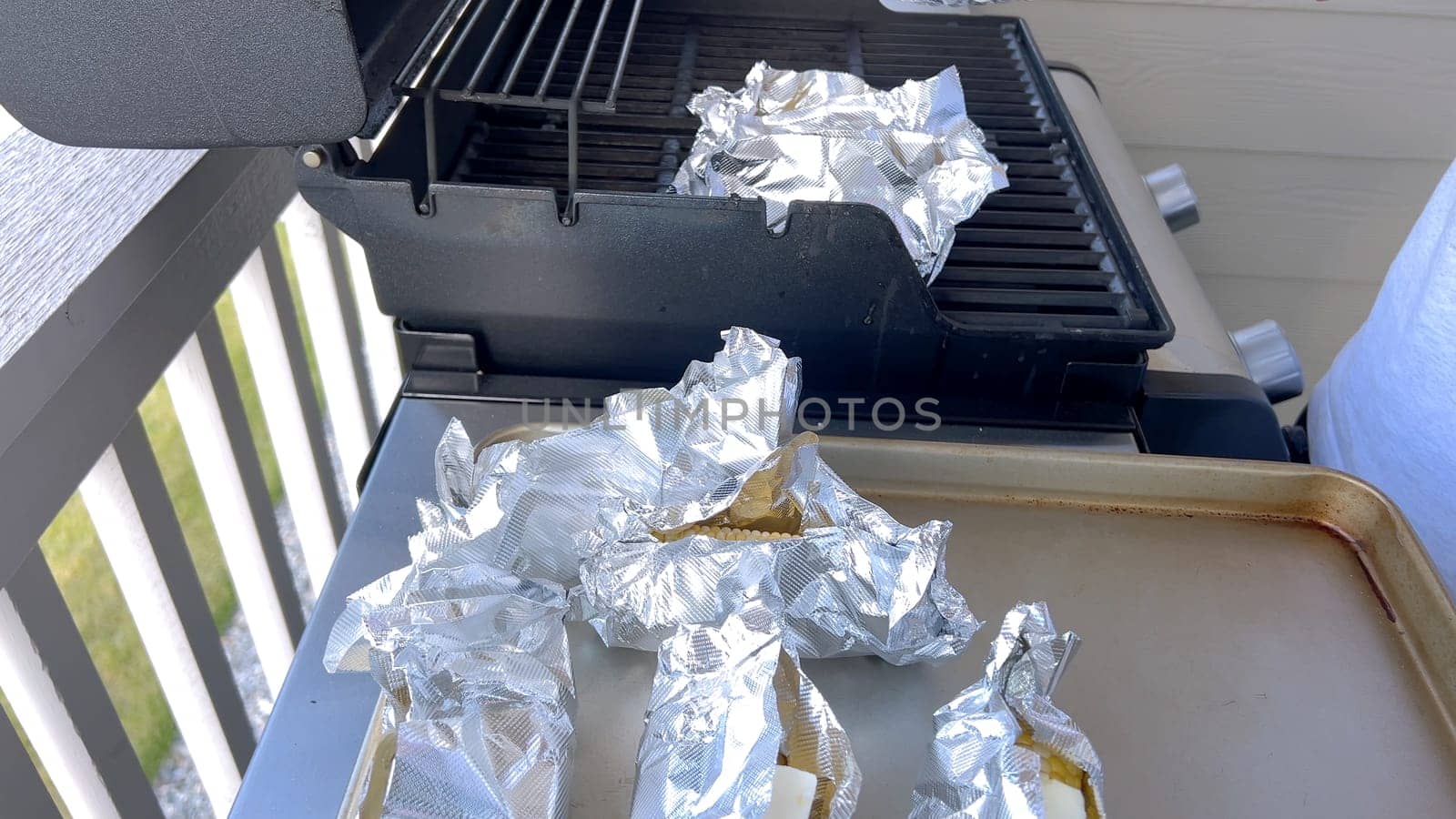 Corn on the Cob Wrapped in Foil Grilling on a Barbecue by arinahabich