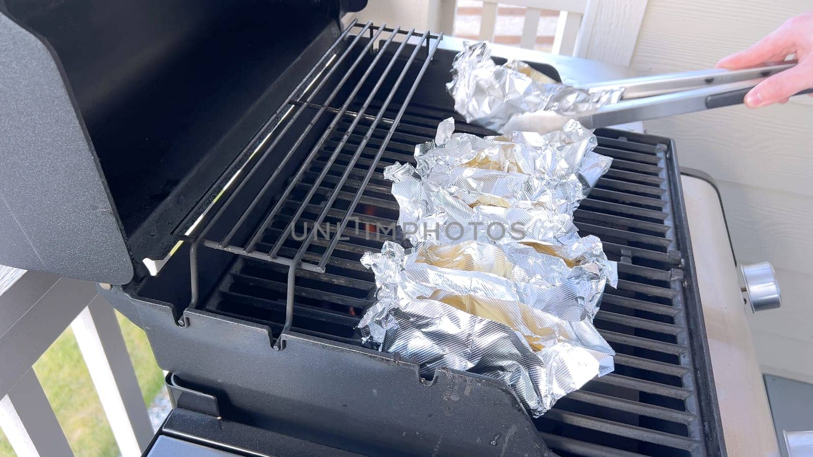 Corn on the Cob Wrapped in Foil Grilling on a Barbecue by arinahabich