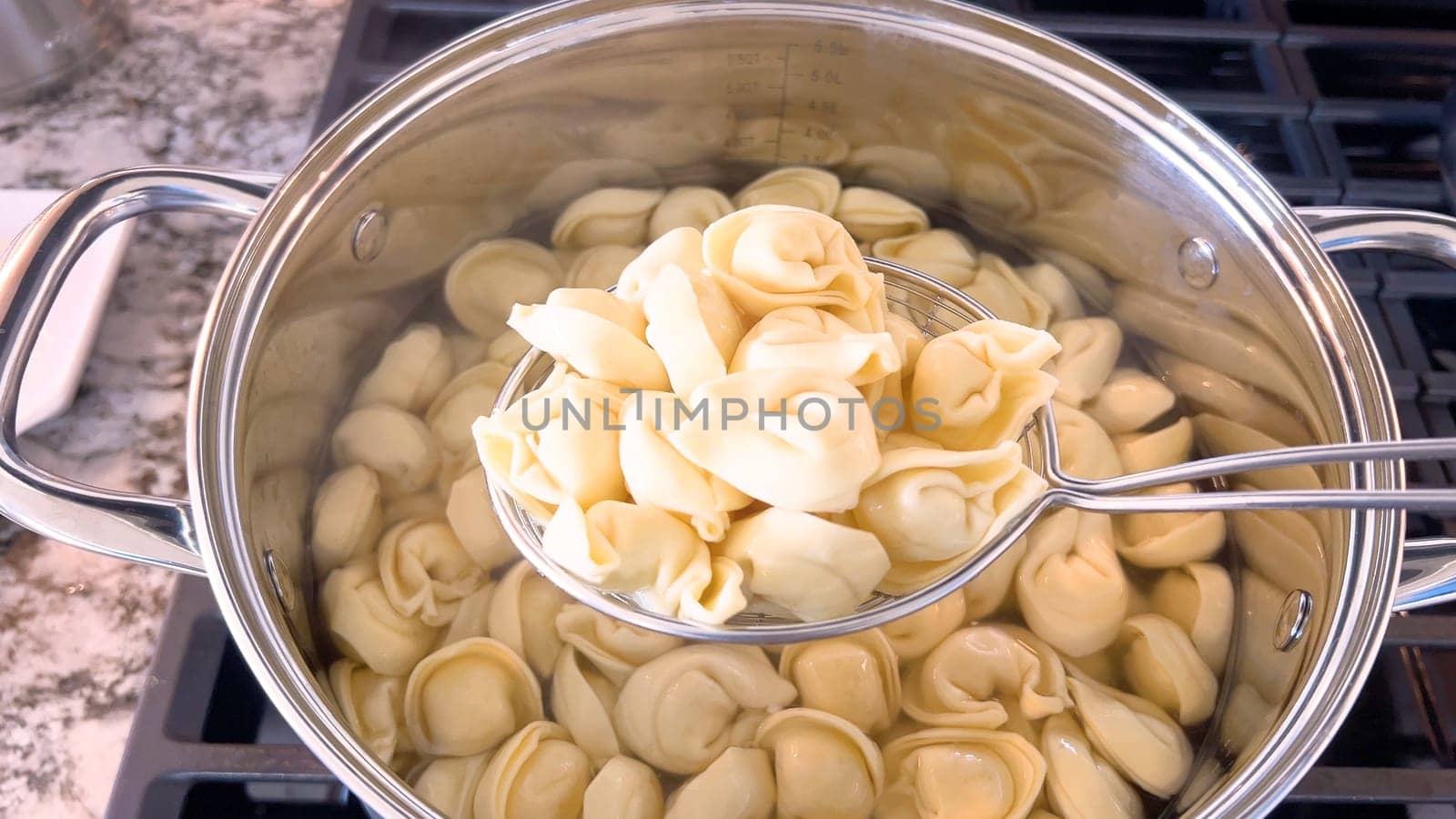 Cooking Tortellini Pasta in a Large Stainless Steel Pot by arinahabich