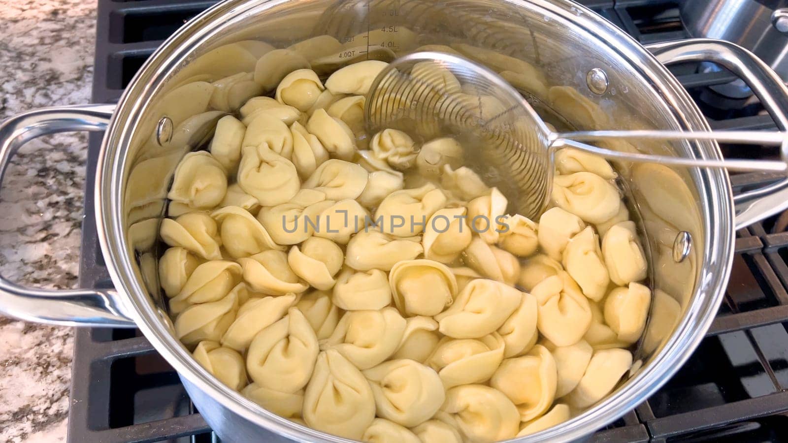 Cooking Tortellini Pasta in a Large Stainless Steel Pot by arinahabich