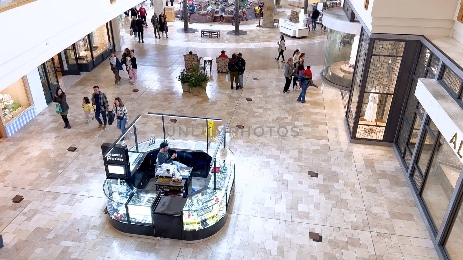 Denver, Colorado, USA-April 28, 2024- Capturing the expansive and airy interior of Park Meadows Mall, this image highlights the modern architectural style with wooden beams, large hanging lights, and a series of vibrant hanging ribbons, creating a lively shopping atmosphere.