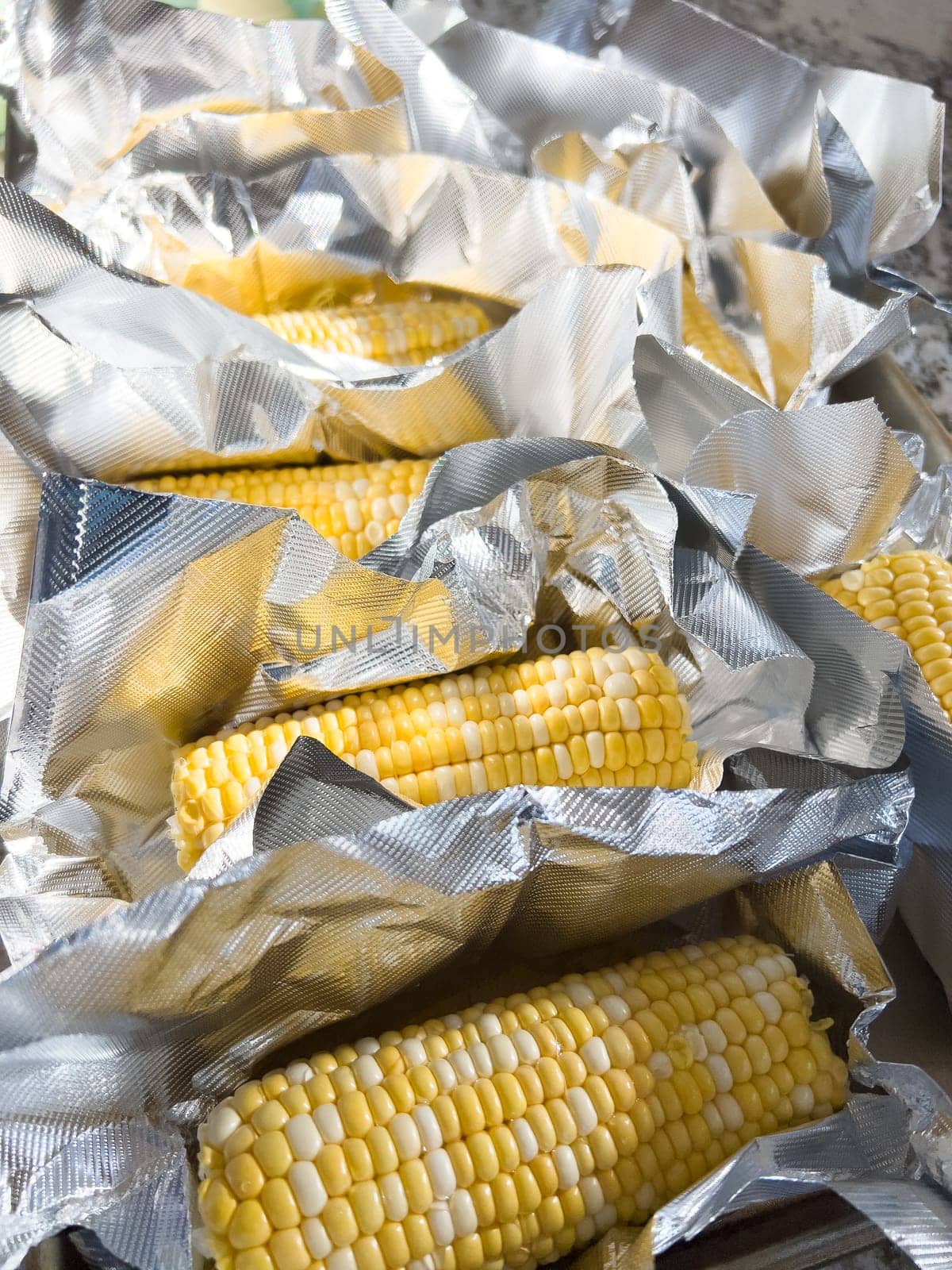 This image showcases fresh corn on the cob, neatly arranged in vacuum-sealed plastic packaging to preserve its freshness and flavor, ready for distribution or sale.