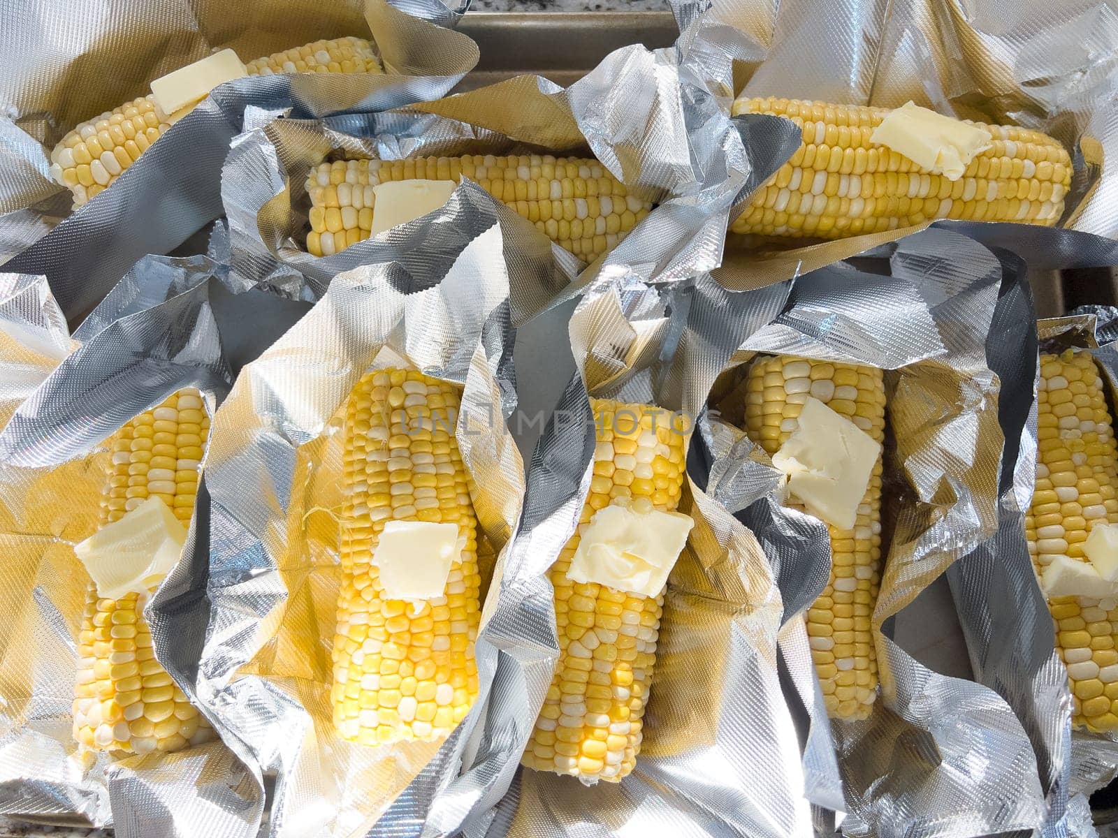 This image showcases fresh corn on the cob, neatly arranged in vacuum-sealed plastic packaging to preserve its freshness and flavor, ready for distribution or sale.