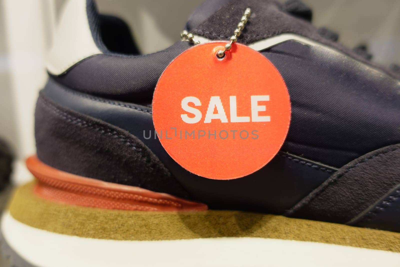 Men sneaker with red sale sign displaying on shelf by towfiq007