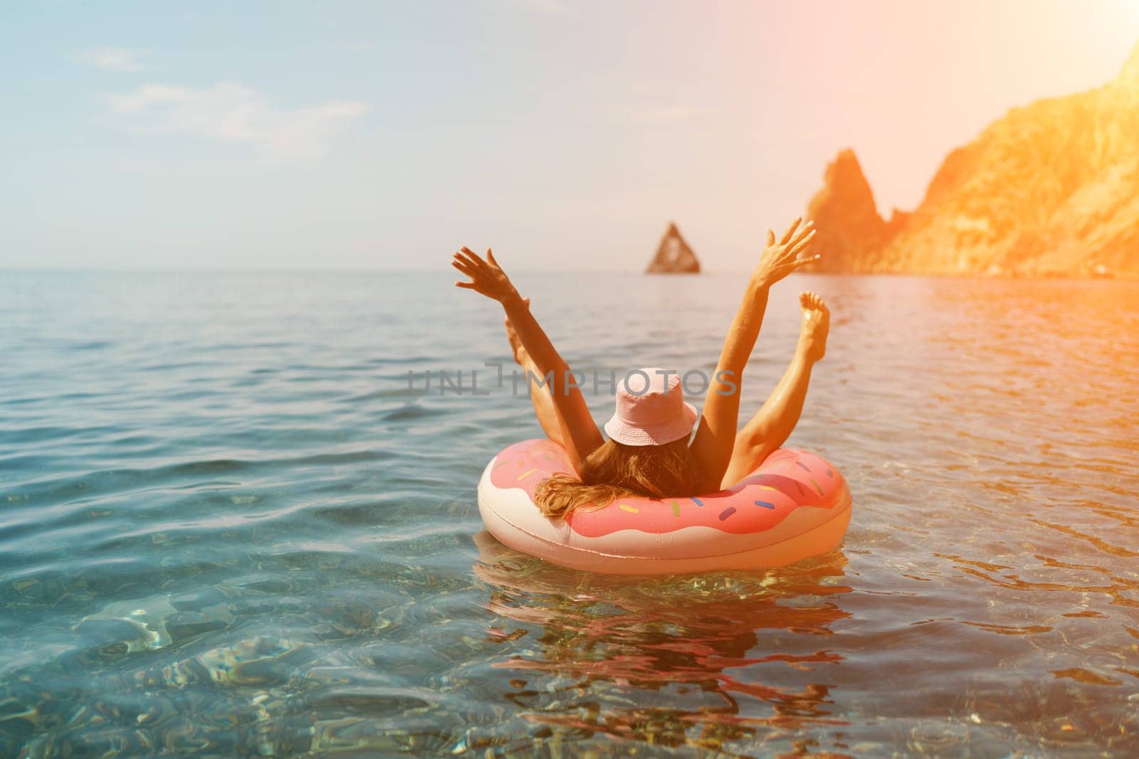 Summer vacation woman in hat floats on an inflatable donut mattress. Happy woman relaxing and enjoying family summer travel holidays travel on the sea