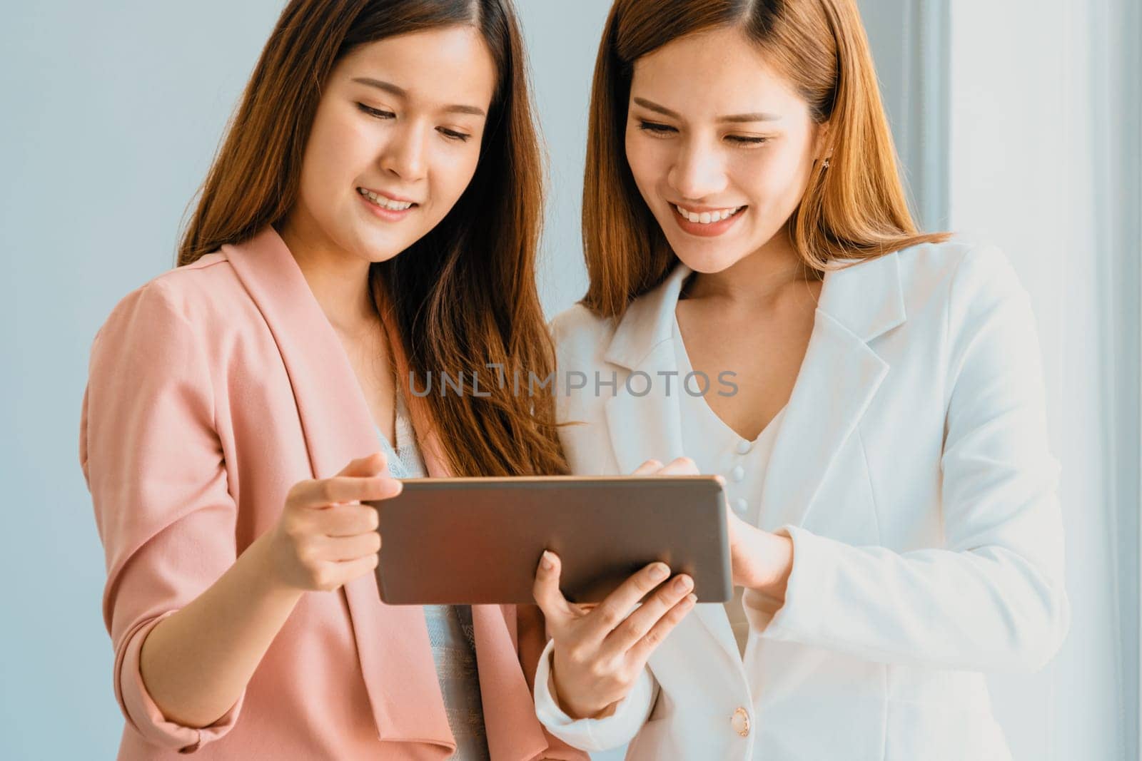 Businesswomen using tablet computer in office. uds by biancoblue