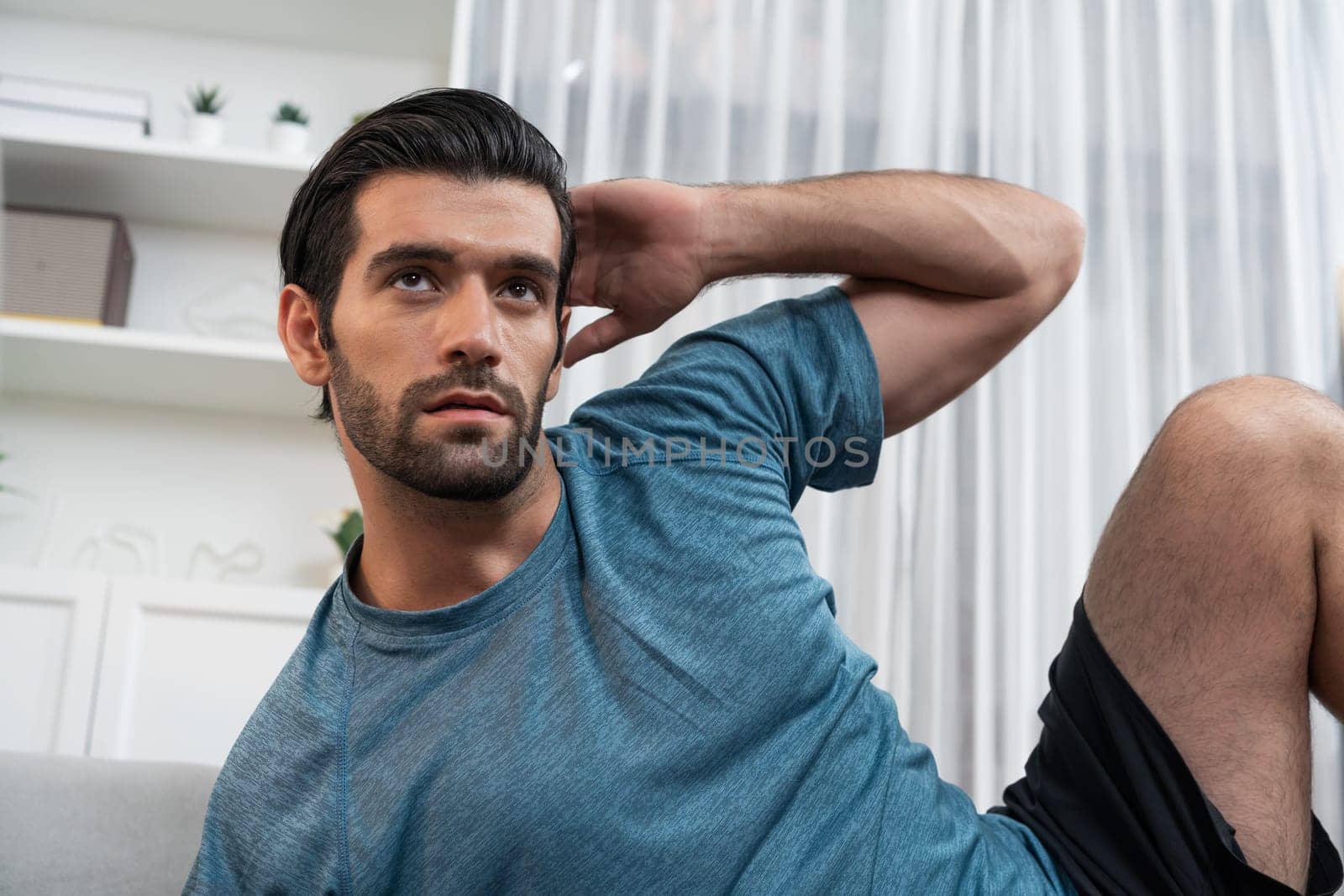 Athletic body and active sporty man using furniture for effective targeting muscle gain exercise at gaiety home exercise as concept of healthy fit body home workout lifestyle.