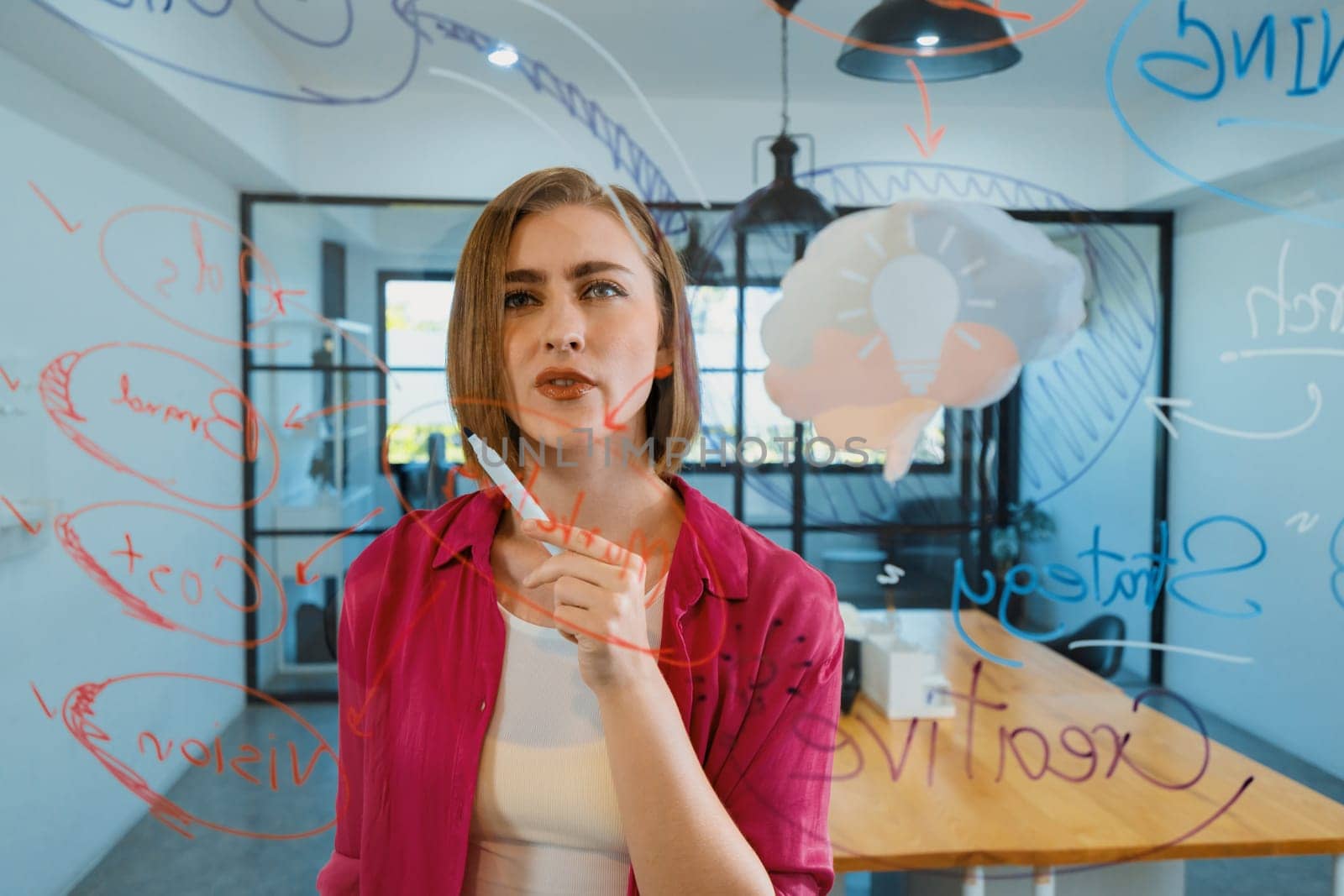 Closeup of attractive smart caucasian businesswoman brainstorms and planing marketing idea by using mind map and colorful sticker on glass board. Creative start up business concept. Immaculate.