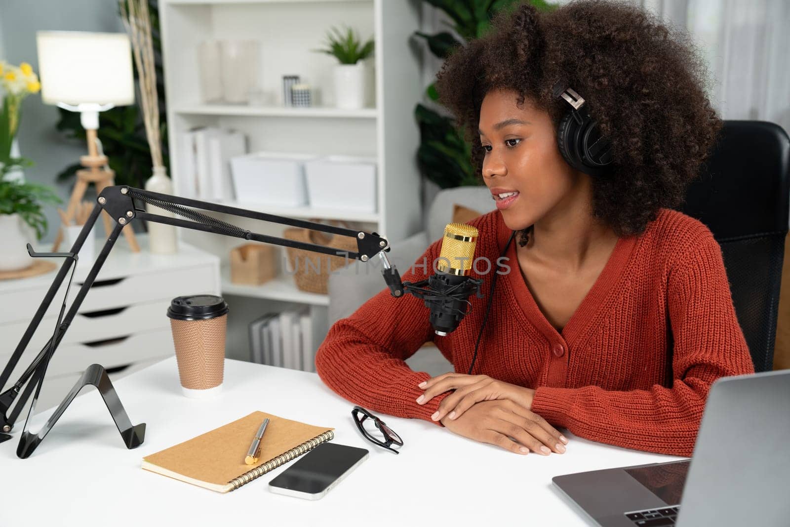 Host channel of beautiful African woman talking in online broadcast teaching marketing influencer, with listeners in broadcast or online. Concept of anywhere at work place. Tastemaker.