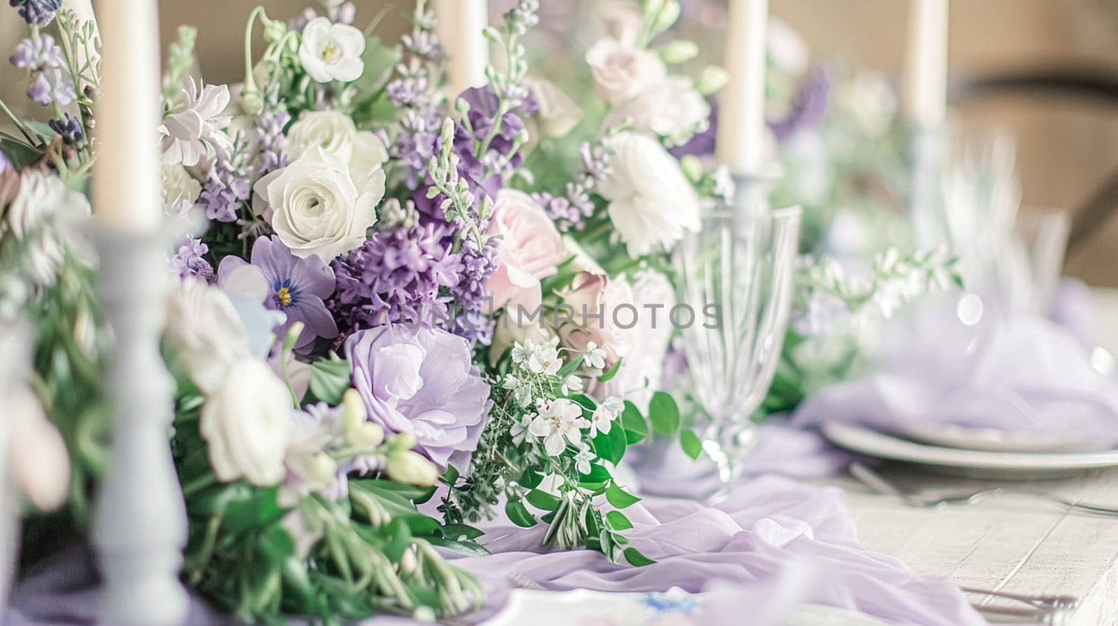 Wedding table decoration with lavender flowers, sweets, cake and candles