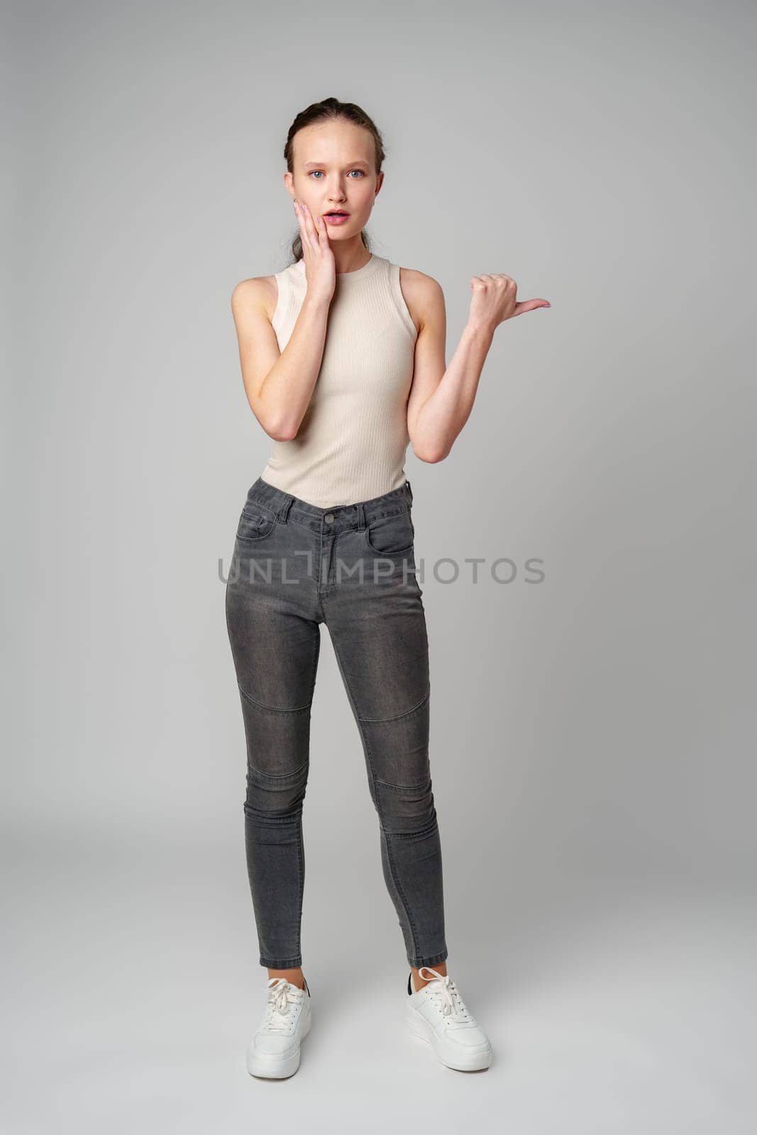 Startled Woman With Surprised Expression on gray background in studio