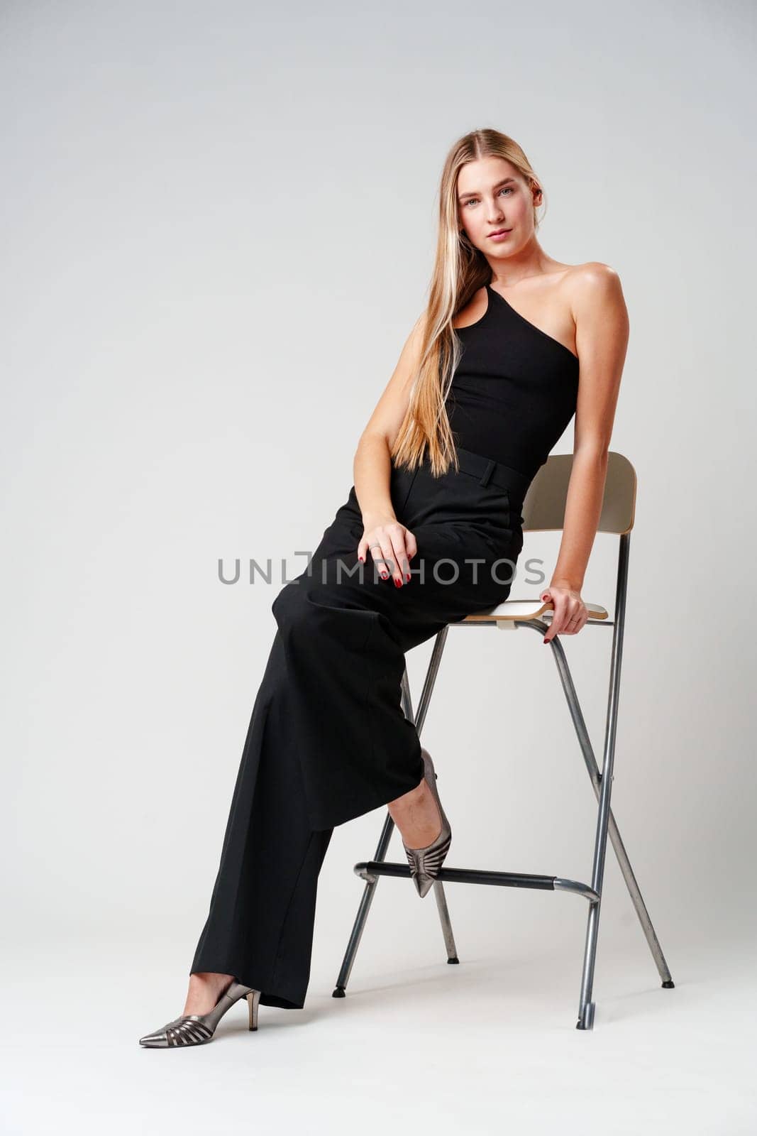 Young Woman Sitting on Chair Posing for Picture by Fabrikasimf