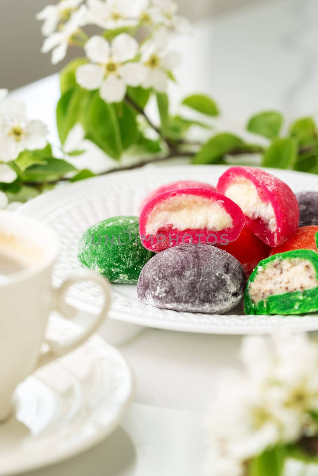 Multi-colored Japanese cakes Mochi in a white plate by Fabrikasimf
