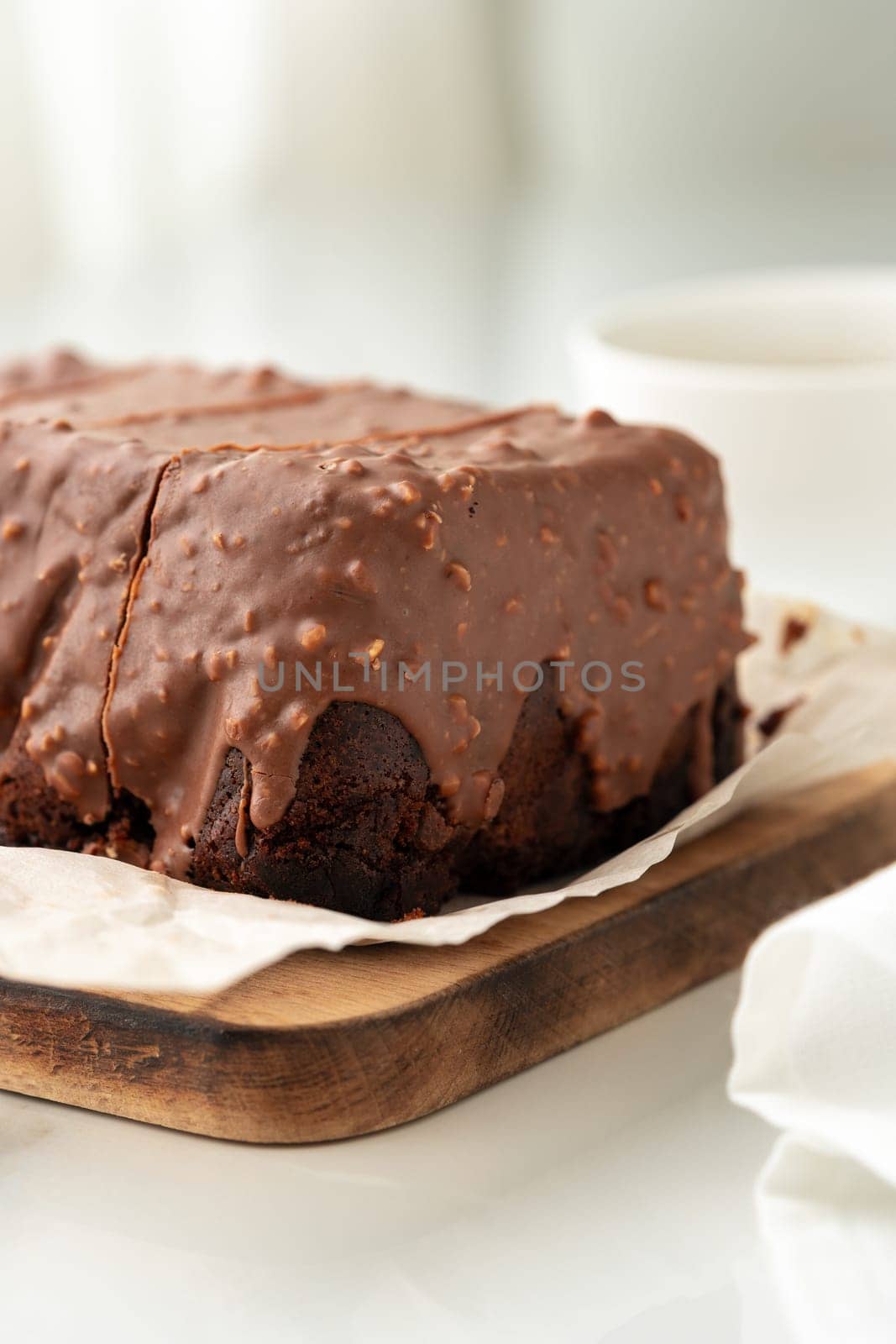 Fresh homemade chocolate sponge cake on wooden board close up