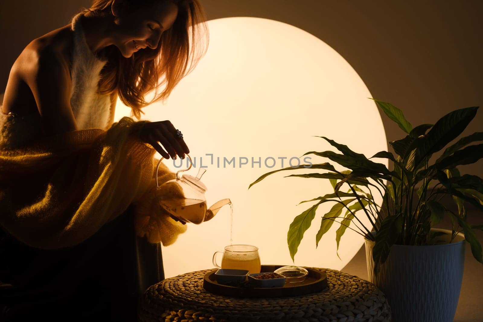 A young girl conducts an evening tea drinking procedure indoors. Relaxing tea party.