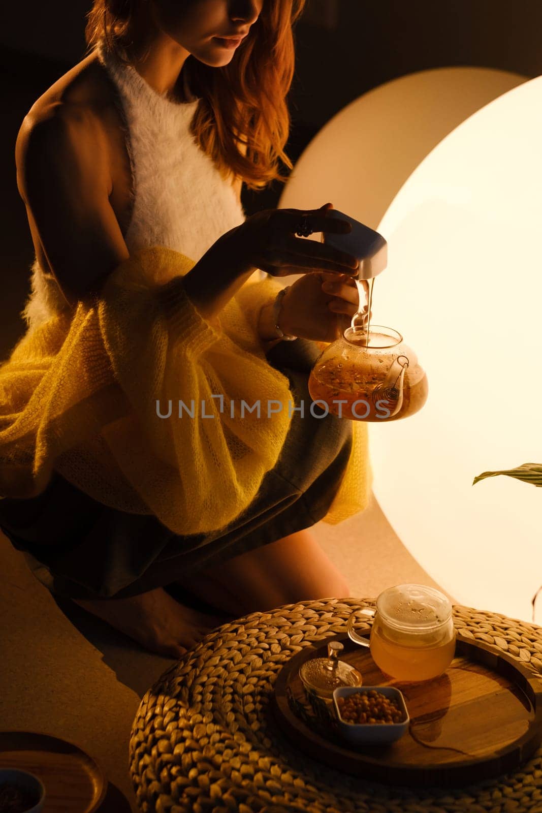 A young girl conducts an evening tea drinking procedure indoors. Relaxing tea party by Lobachad