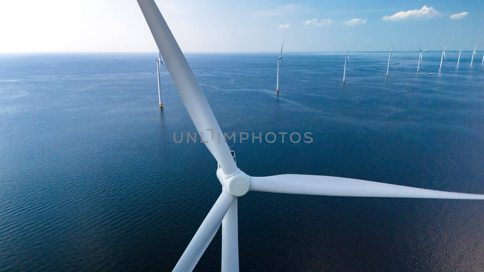 Towering windmill turbines are intricately placed in the vast ocean expanse of the Netherlands Flevoland region, harnessing the power of the wind to generate clean energy.