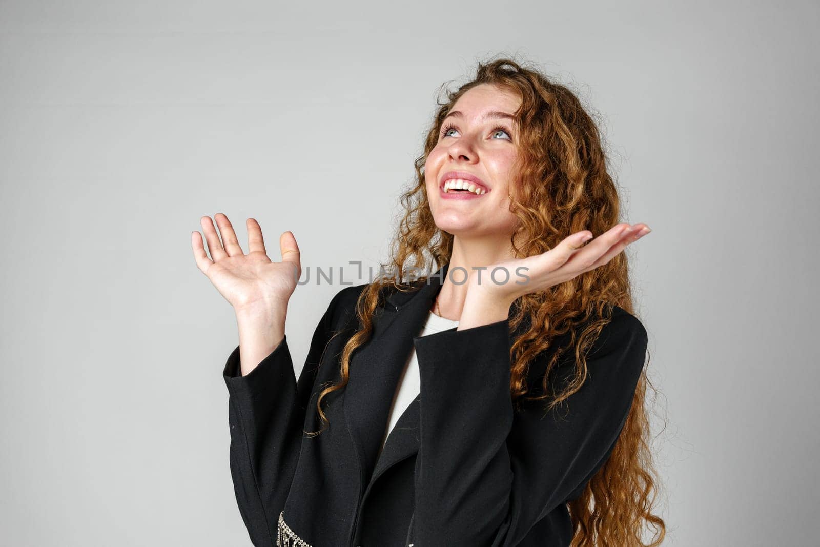 Young Businesswoman Gesturing Excitement or Surprise Against a Neutral Background by Fabrikasimf