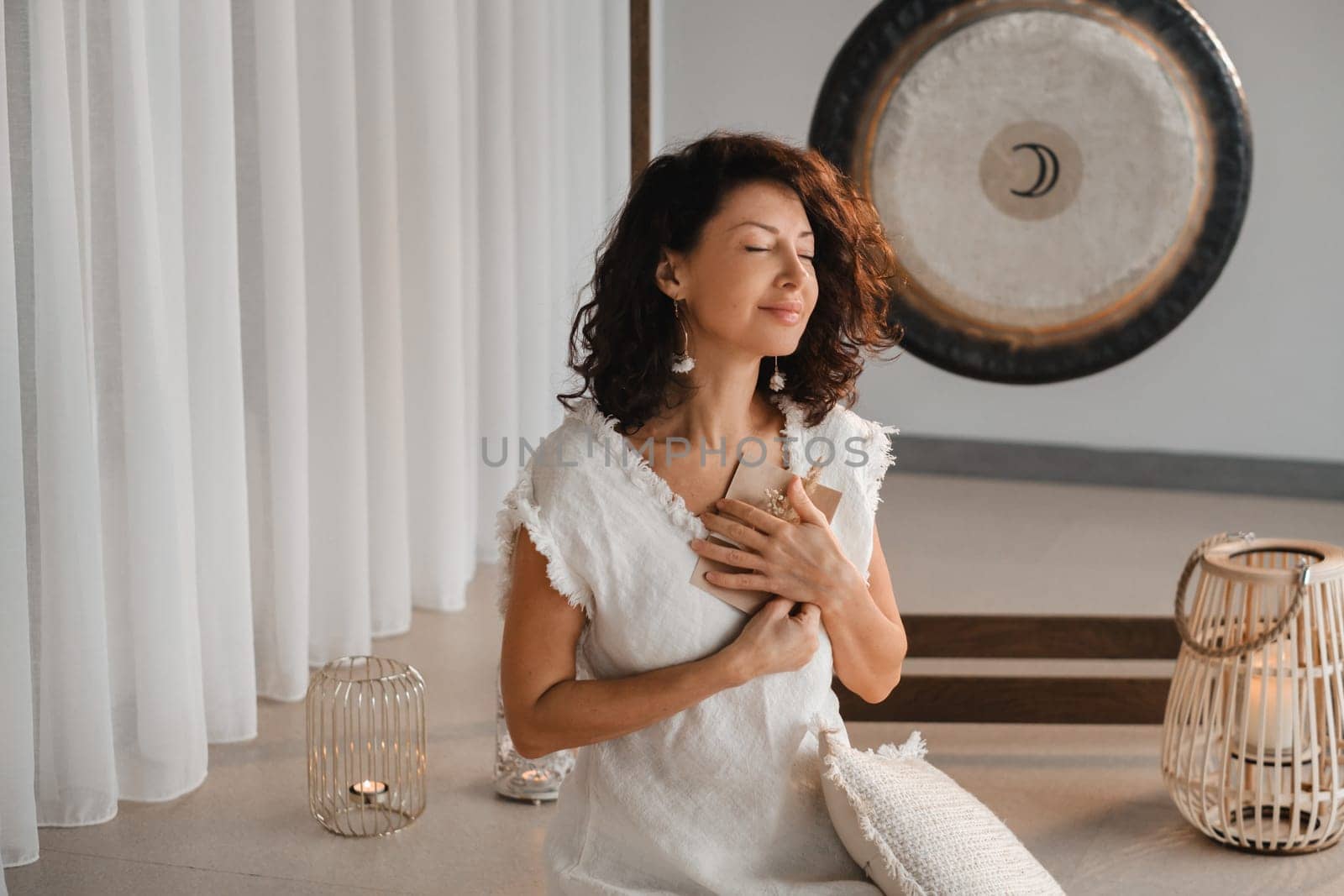 A woman in white clothes holds an envelope with a wish in her hands. The concept of a women's circle.