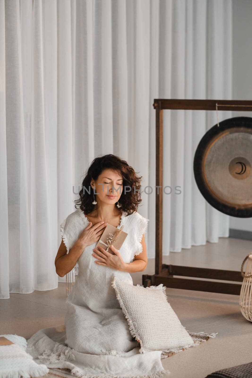 A woman in white clothes holds an envelope with a wish in her hands. The concept of a women's circle.