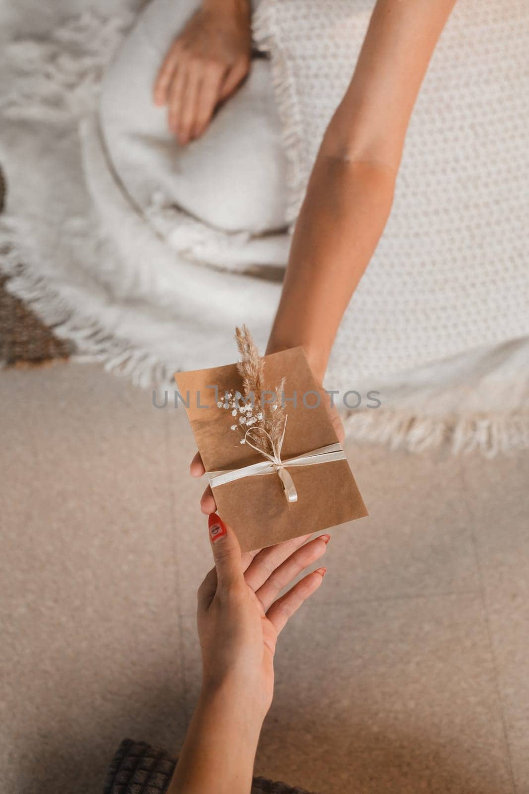A woman in white clothes passes an envelope with a wish to another woman. The concept of the women's circle.