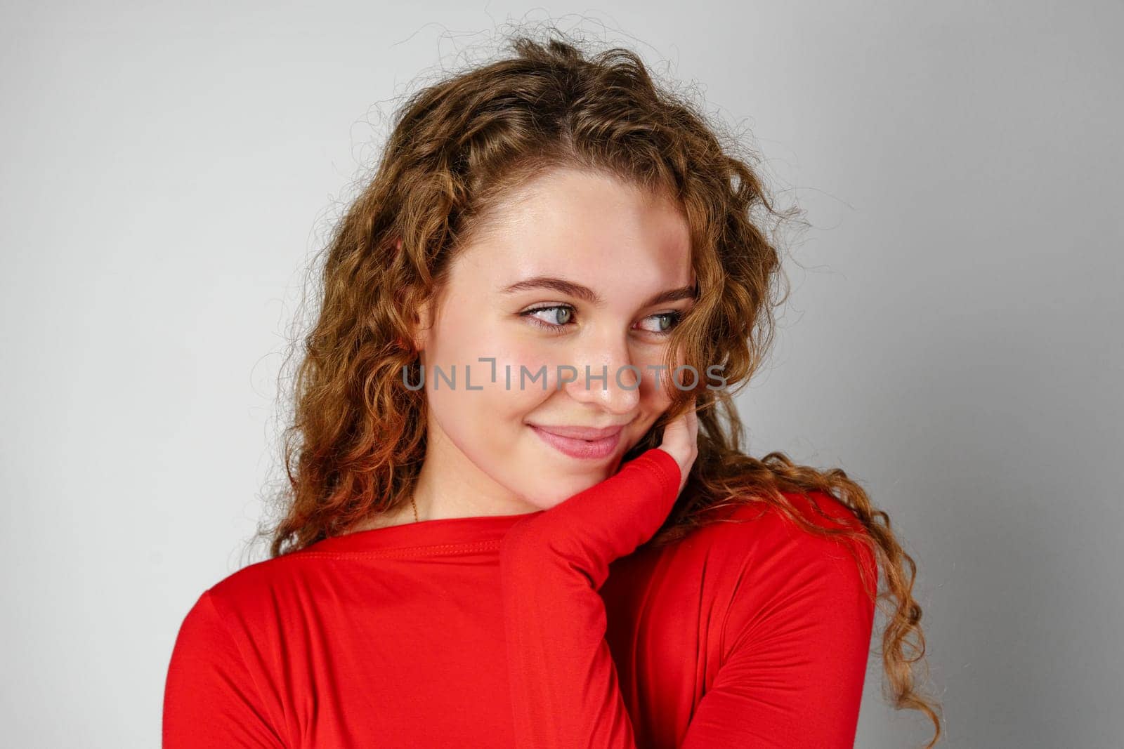Woman With Curly Hair Standing on Gray Background portrait