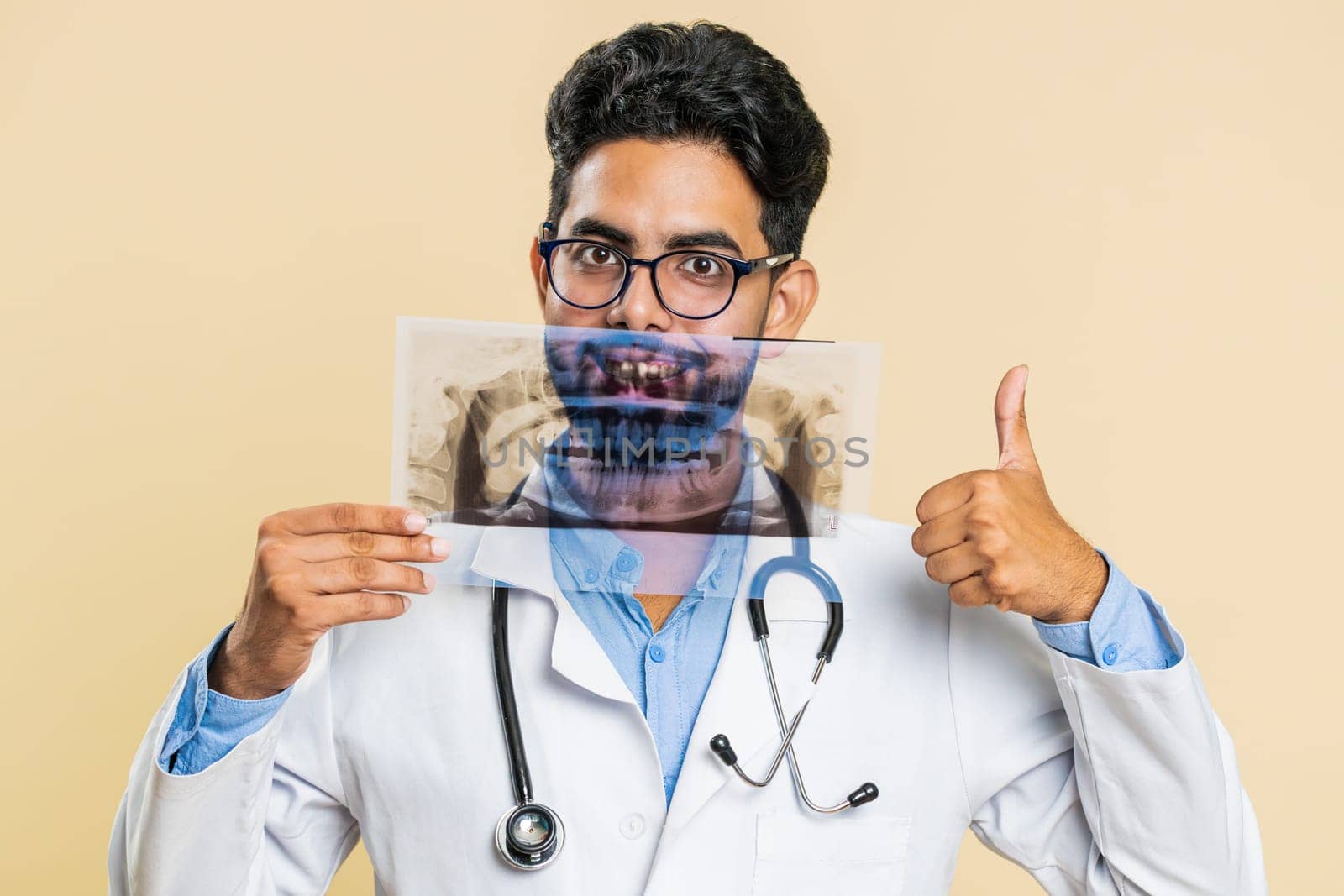 Indian young doctor orthodontist man examines a panoramic x-ray picture of the jaw teeth stomatology by efuror