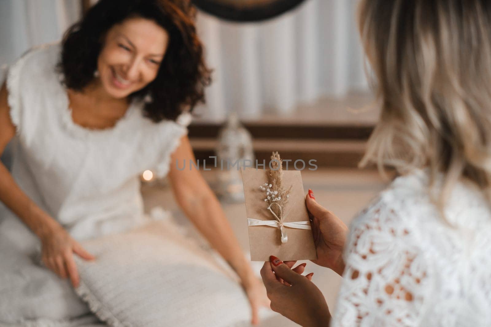 A woman in white clothes passes an envelope with a wish to another woman. The concept of the women's circle.