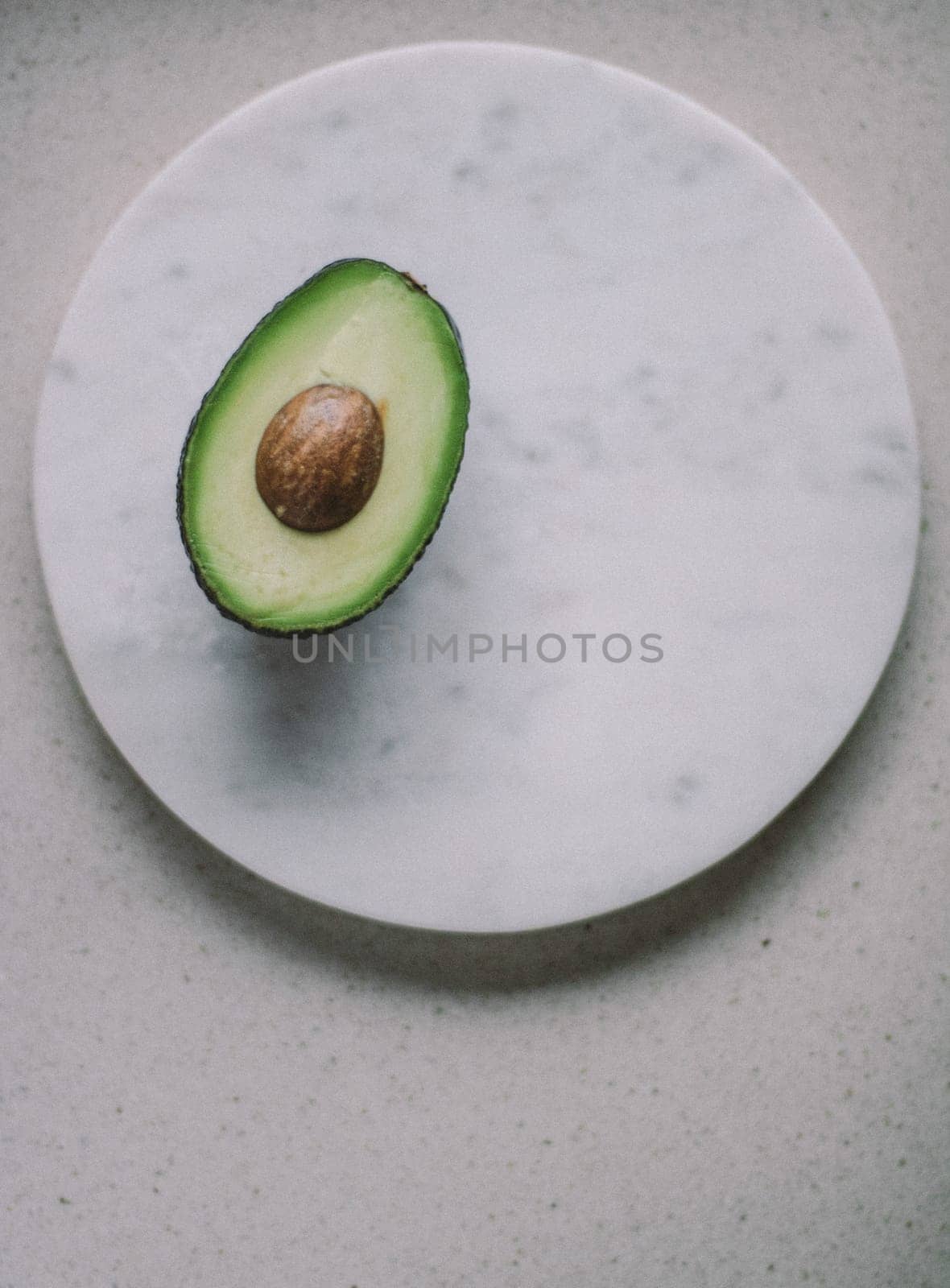 avocado on marble table - organic vegetables and healthy eating styled concept by Anneleven