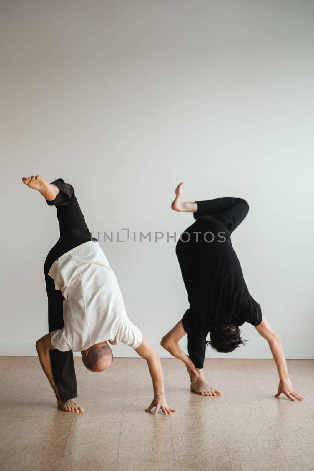 two young athletes practice yoga in the gym. Joint training, indoors, studio. The concept of a healthy lifestyle.