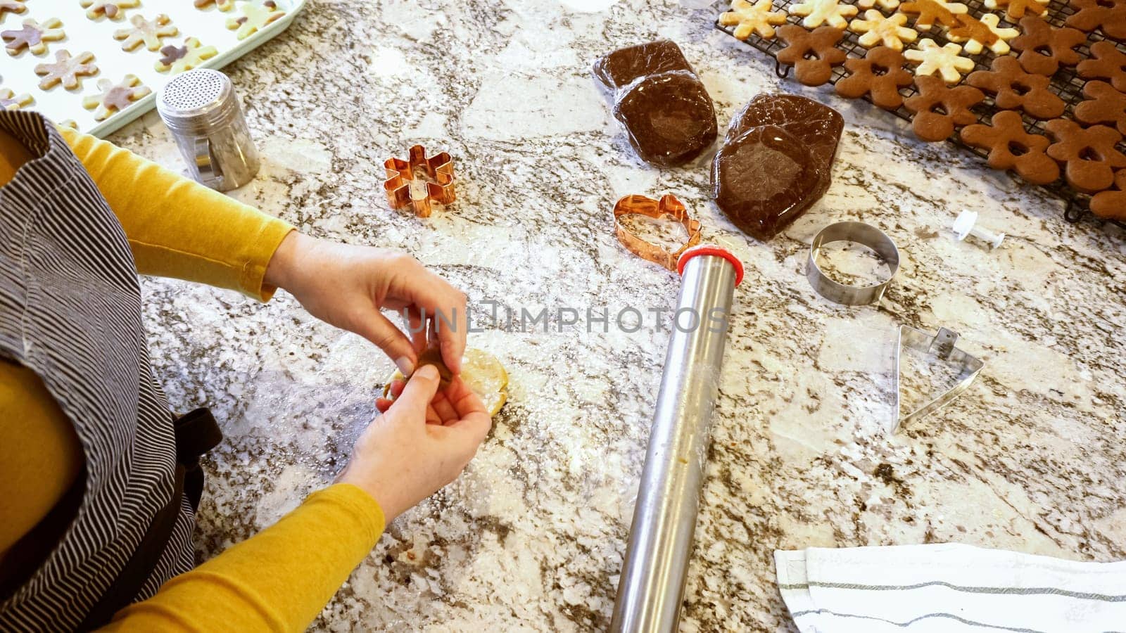 Using an adjustable rolling pin to roll out gingerbread cookie dough on the elegant marble counter in a modern kitchen, getting ready for festive holiday baking.