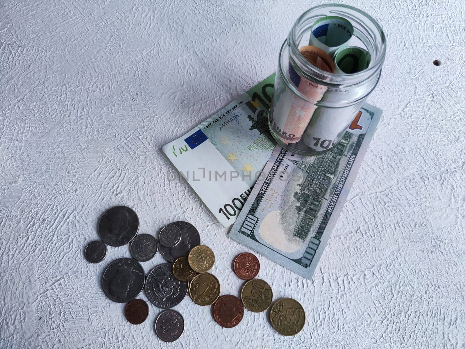 Glass Jar Filled With Euro Banknotes and Coins on Table. Concept of savings ranging from small money to large by keleny