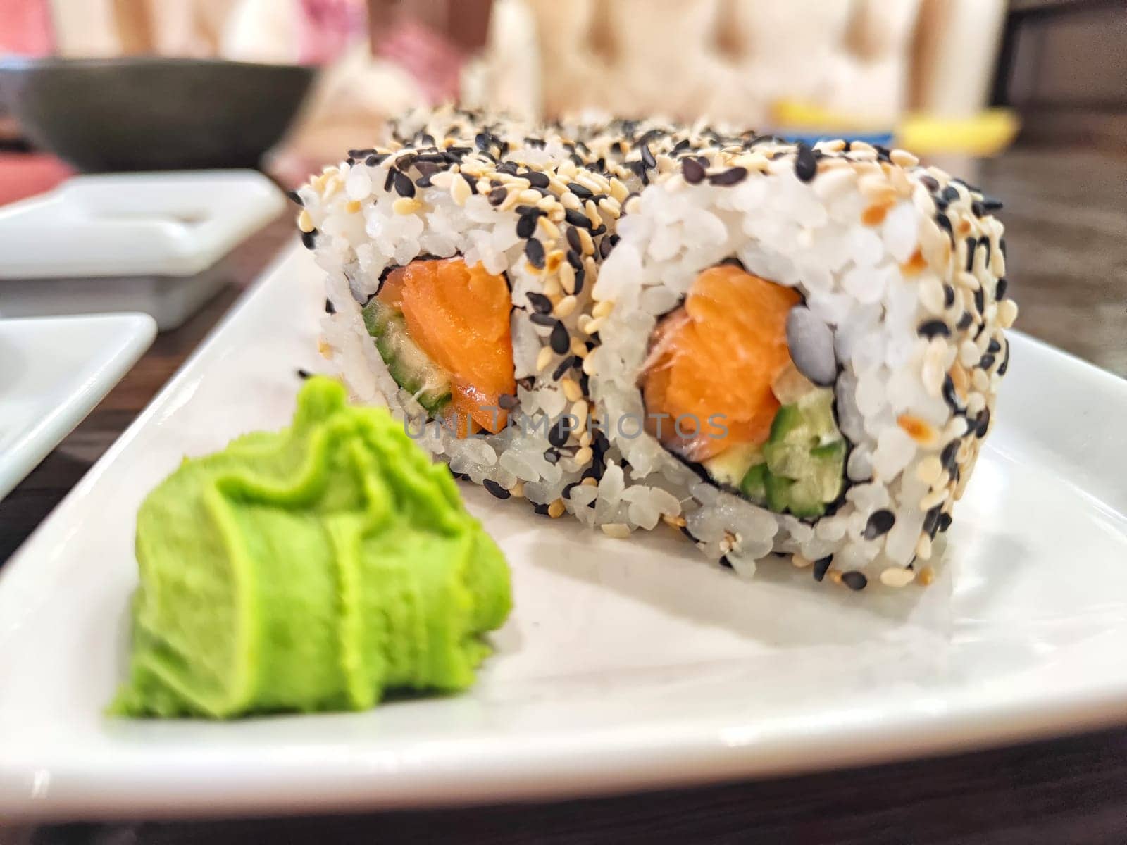 Sushi rolls with fresh ingredients served on platter. Japanese Sushi Rolls on White Plate With Ginger Garnish. Blurred and Partial focus