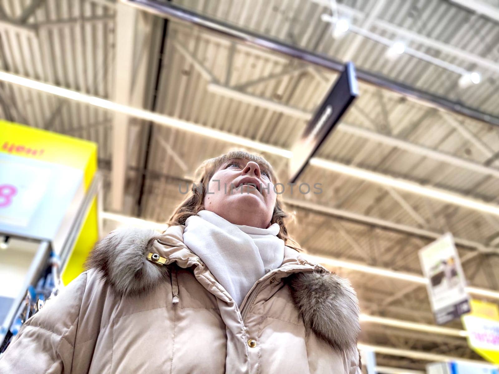 Middle-Aged Woman Shopping at a Warehouse Store. Woman browsing in a large retail store aisle by keleny