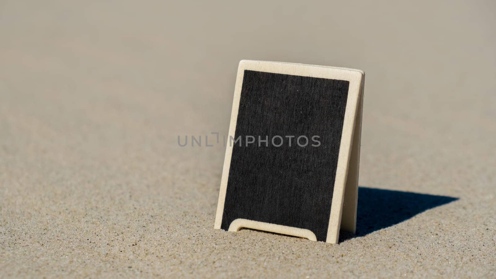 Empty blackboard frame board with copy space for your text or design displays on sandy beach. Summer vacation and holiday business travel concept. Template Mock up for sale promotion advertisement. Travelling, trip Chalkboard