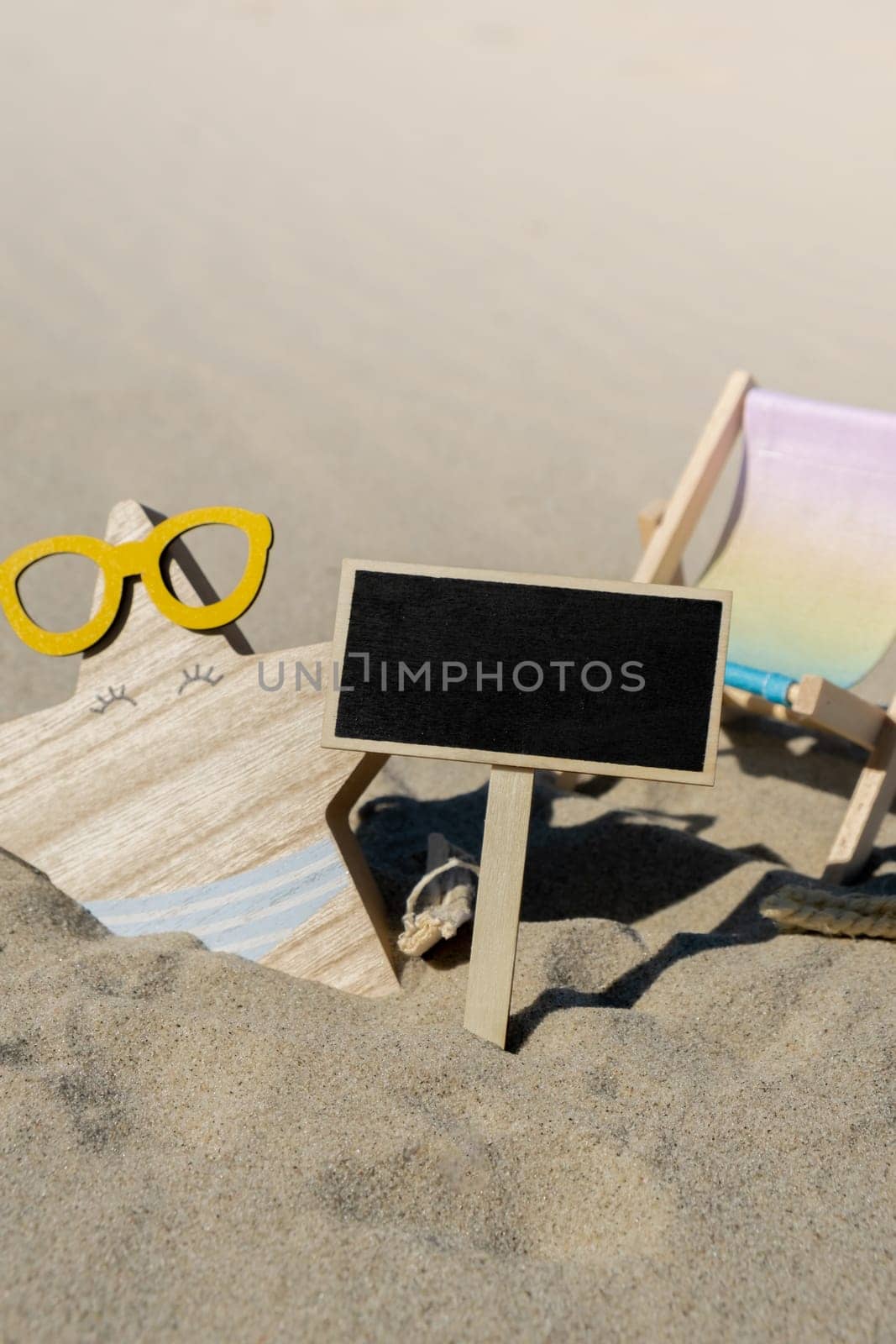 Empty blackboard frame board with copy space for your text or design displays on sandy beach. Starfish in glasses and beach chair decoration. Summer vacation and holiday business travel concept. Template Mock up for sale promotion advertisement. Travelling, trip Chalkboard