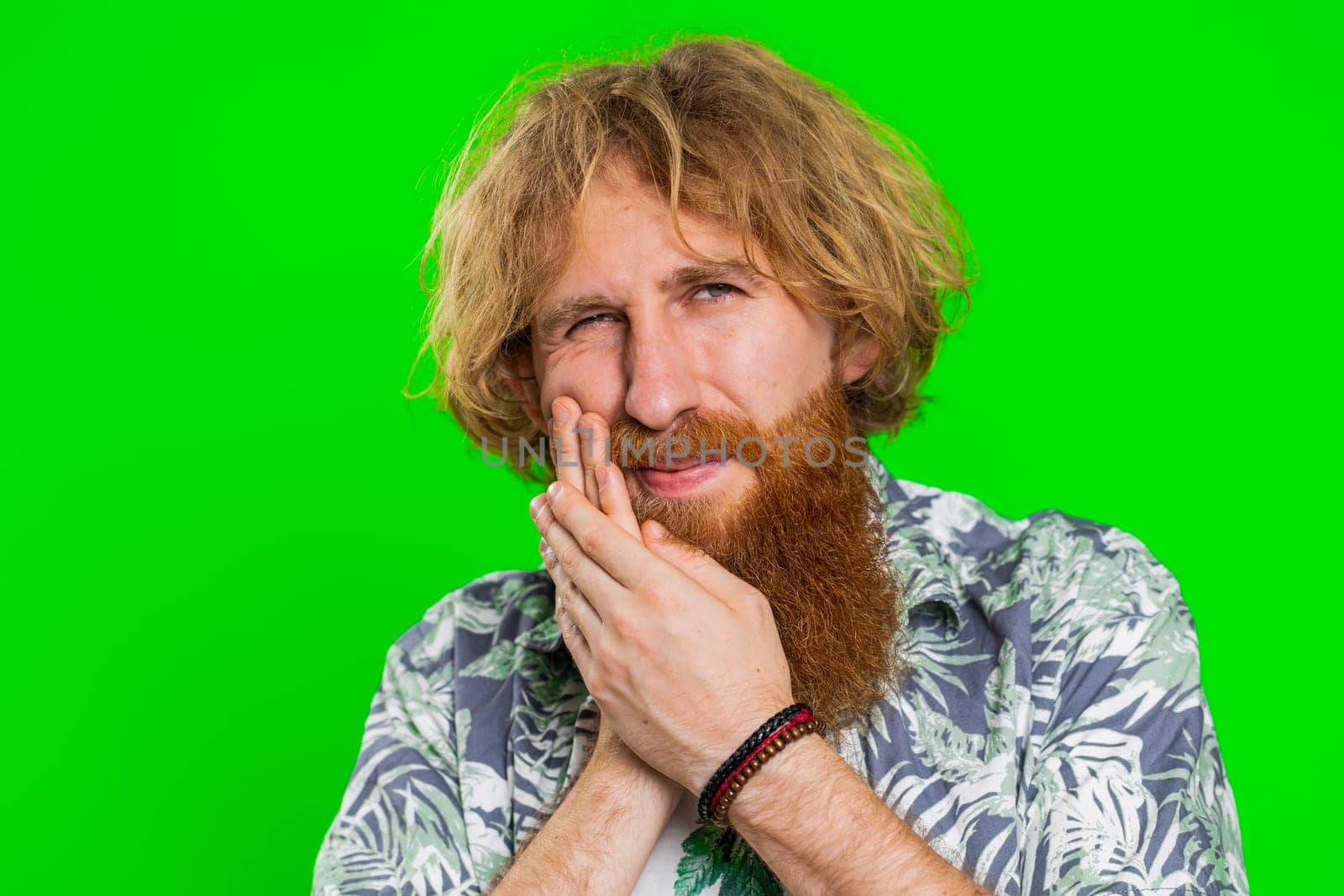 Young man touching cheek, closing eyes with expression of terrible suffer from painful toothache by efuror