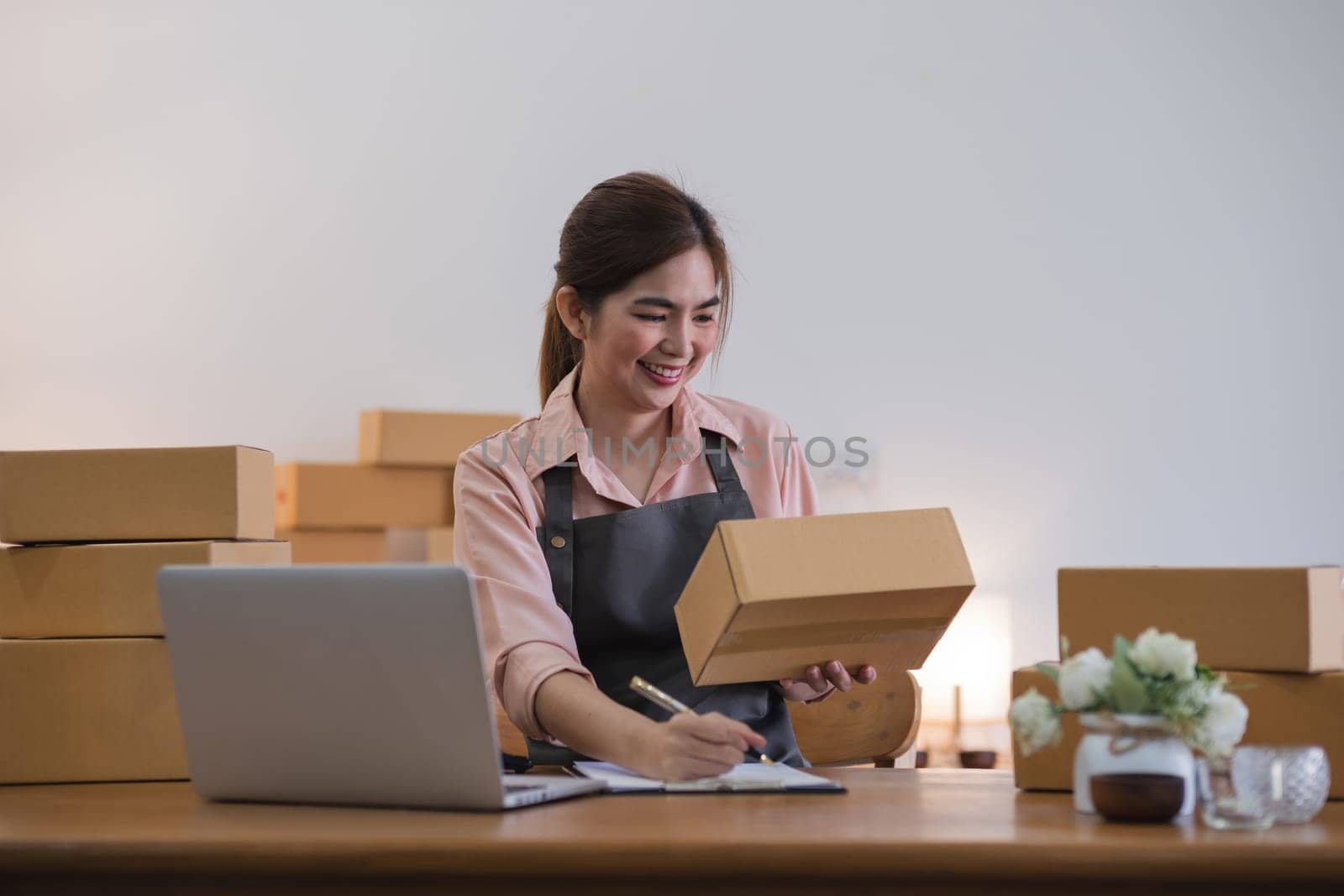 Business From Home Asian woman preparing package delivery box Shipping for shopping online. young start up small business owner at home online order by wichayada