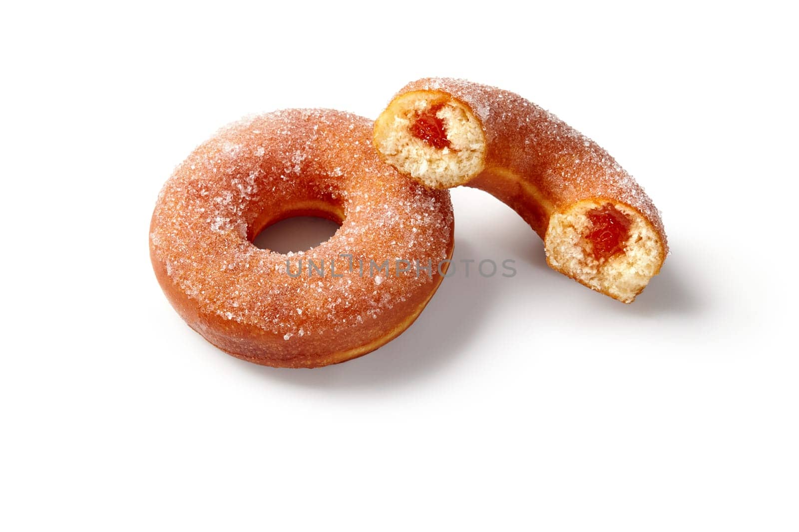 Close-up of soft fluffy sugar coated donuts with fruit jelly filling, against pure white backdrop. Concept of popular confectionery